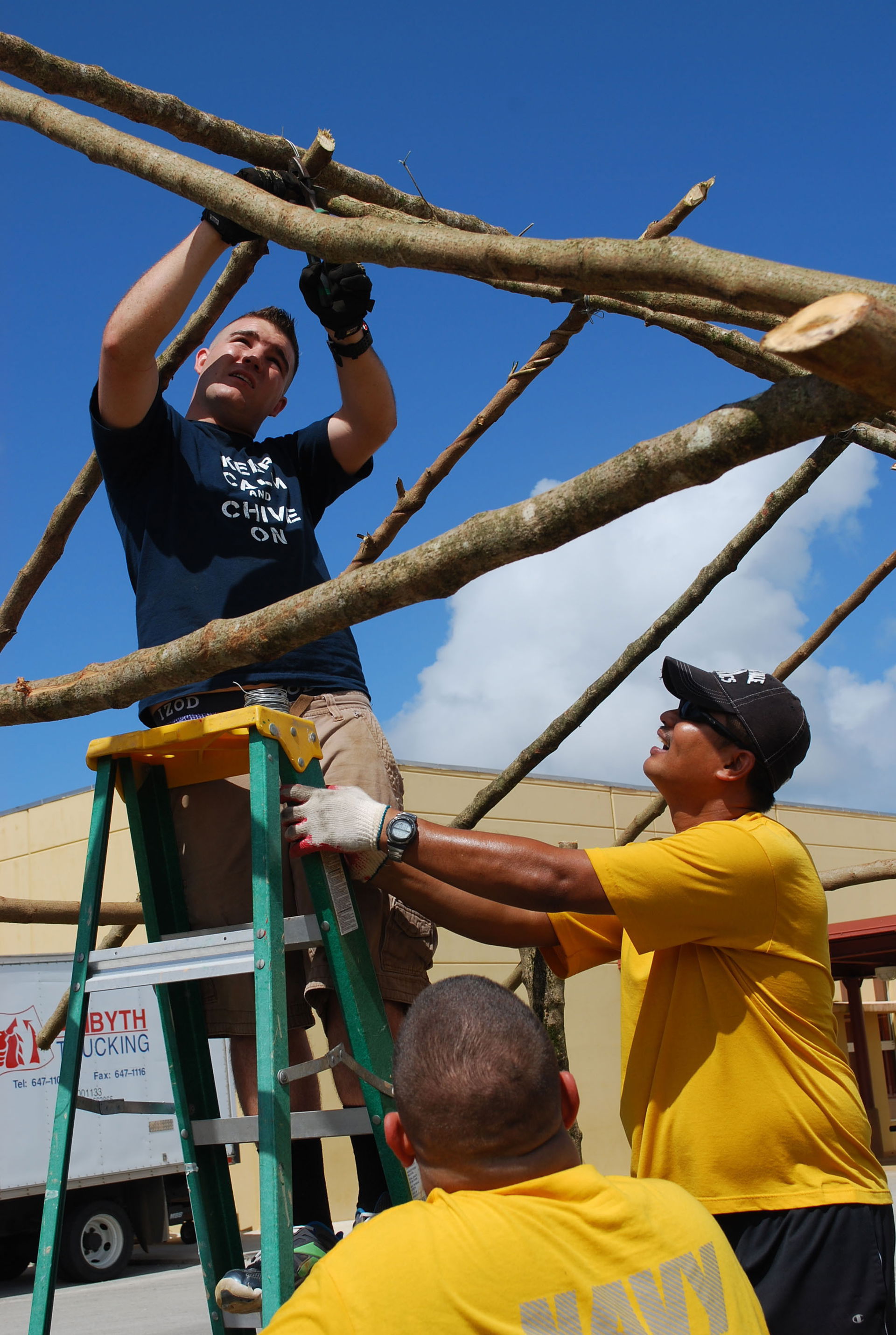 Sailors assigned to the submarine tender USS Frank Cable build …
