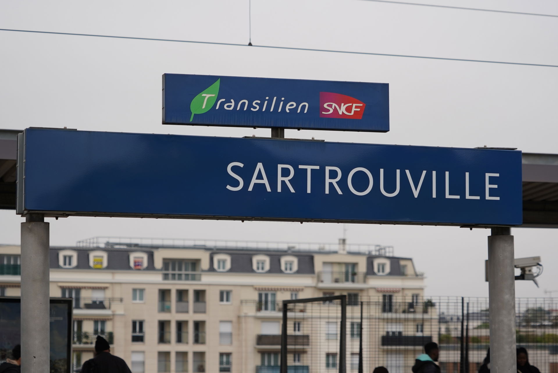 Panneau du nom de la gare de Sartrouville sur le quai.