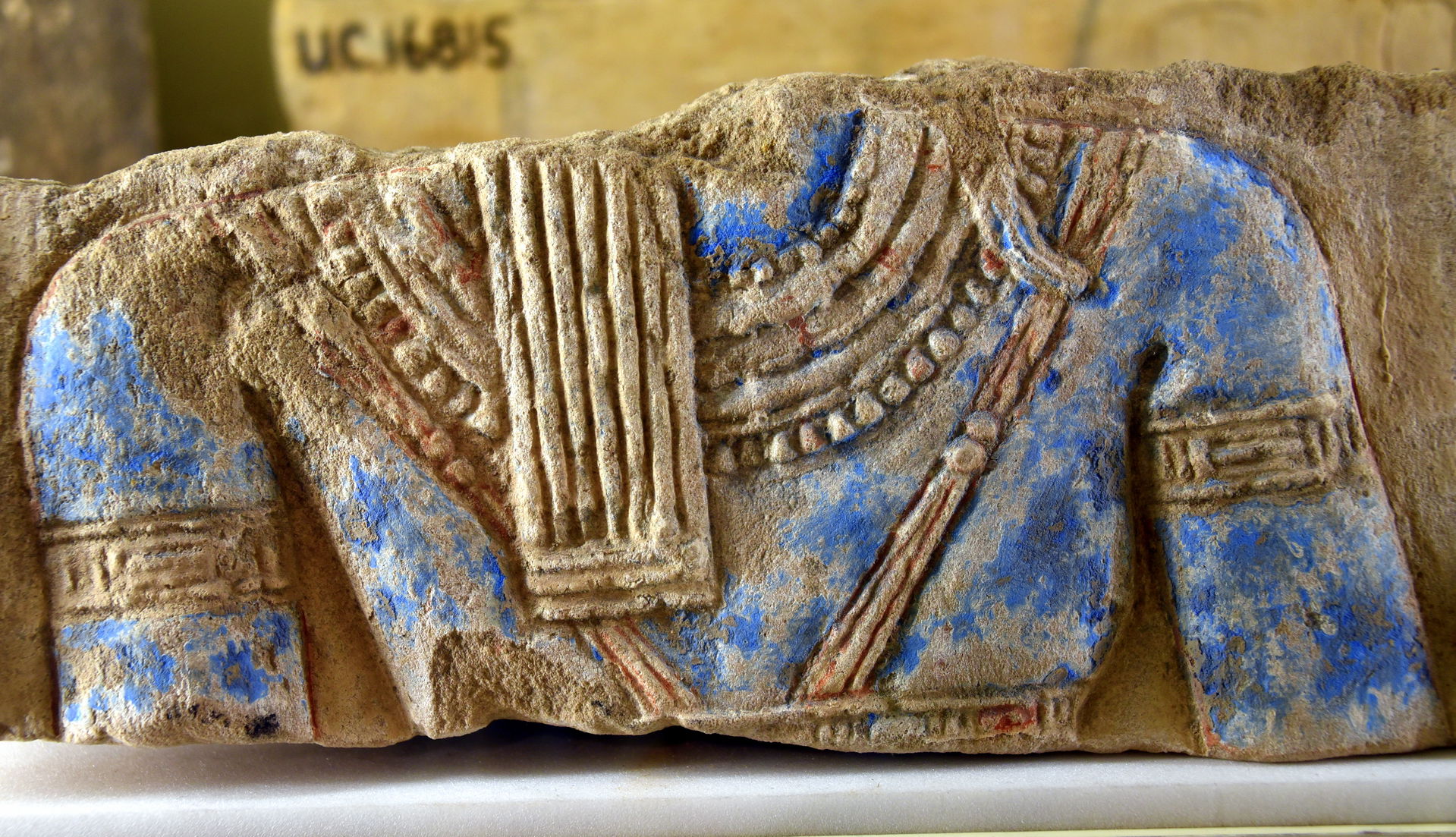 Sandstone block with a blue-painted torso, probably representin…