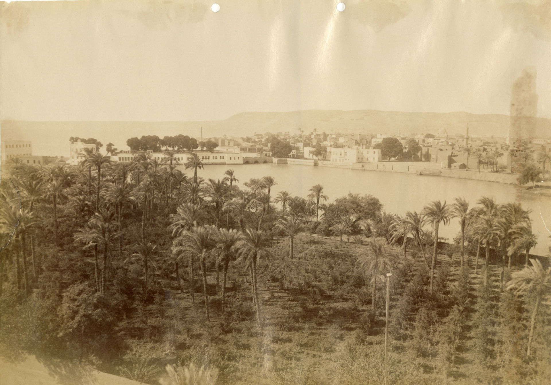 The photograph shows a view of the village of Asyut during one …