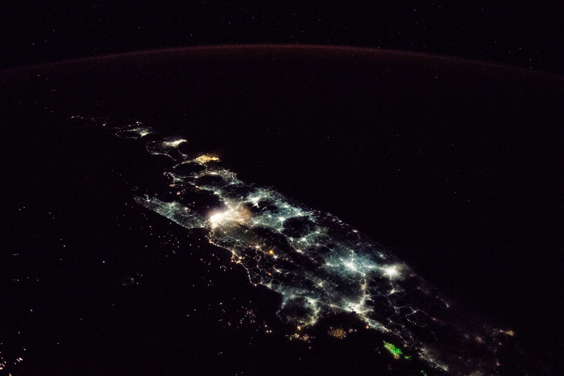This oblique nighttime image, taken by an astronaut aboard the …