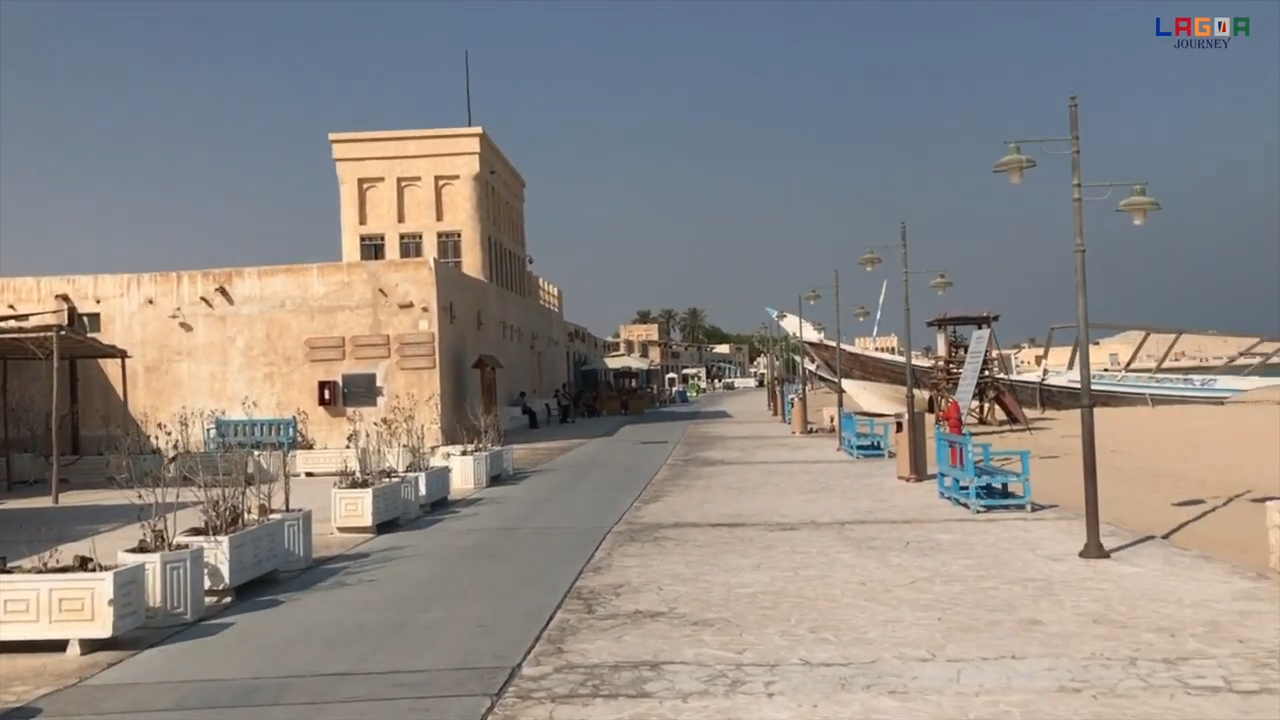 Walkway in Al Wakrah Old Souq. A dhow on the beach can be seen …