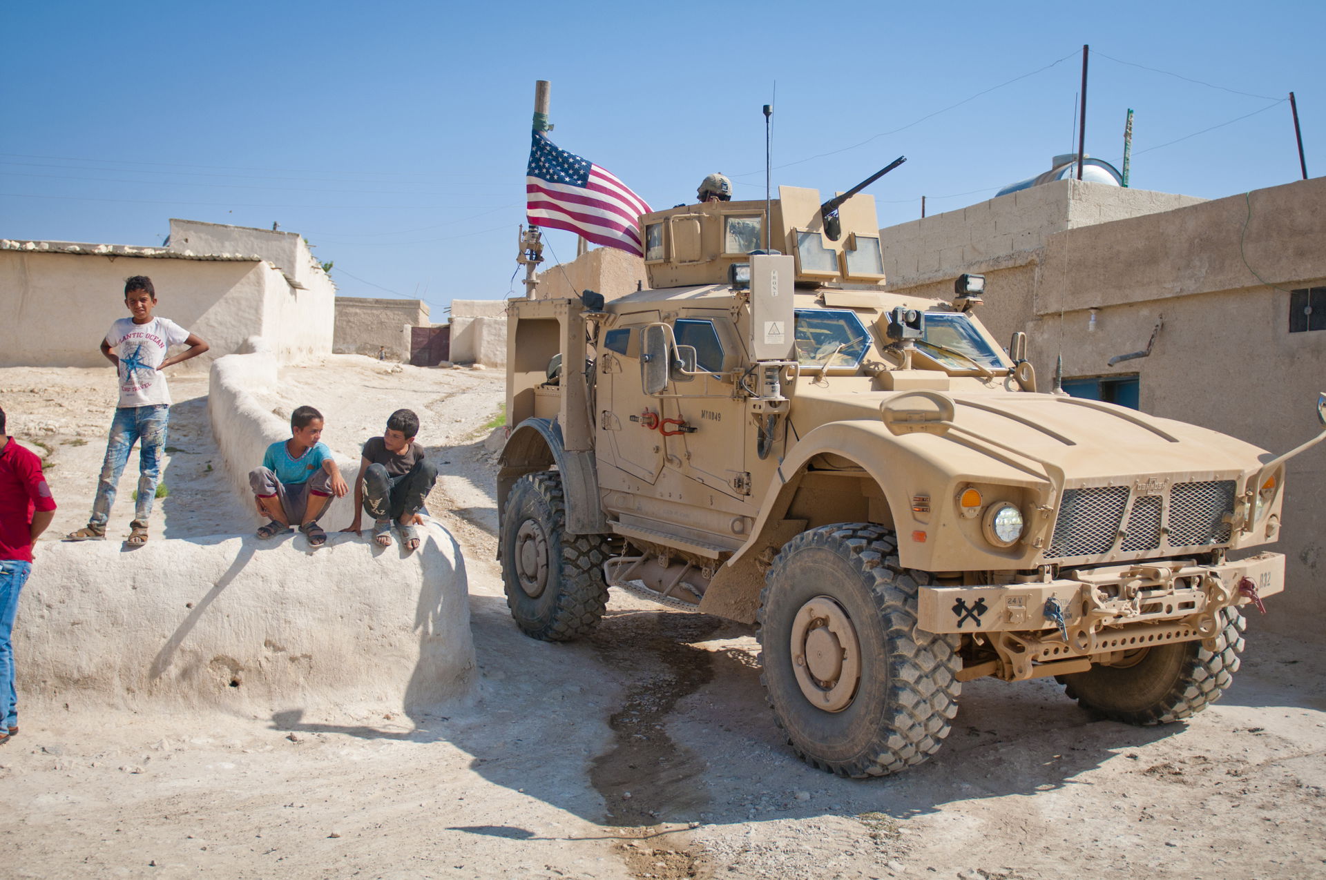 Children gather around a U.S. tactical vehicle during an indepe…
