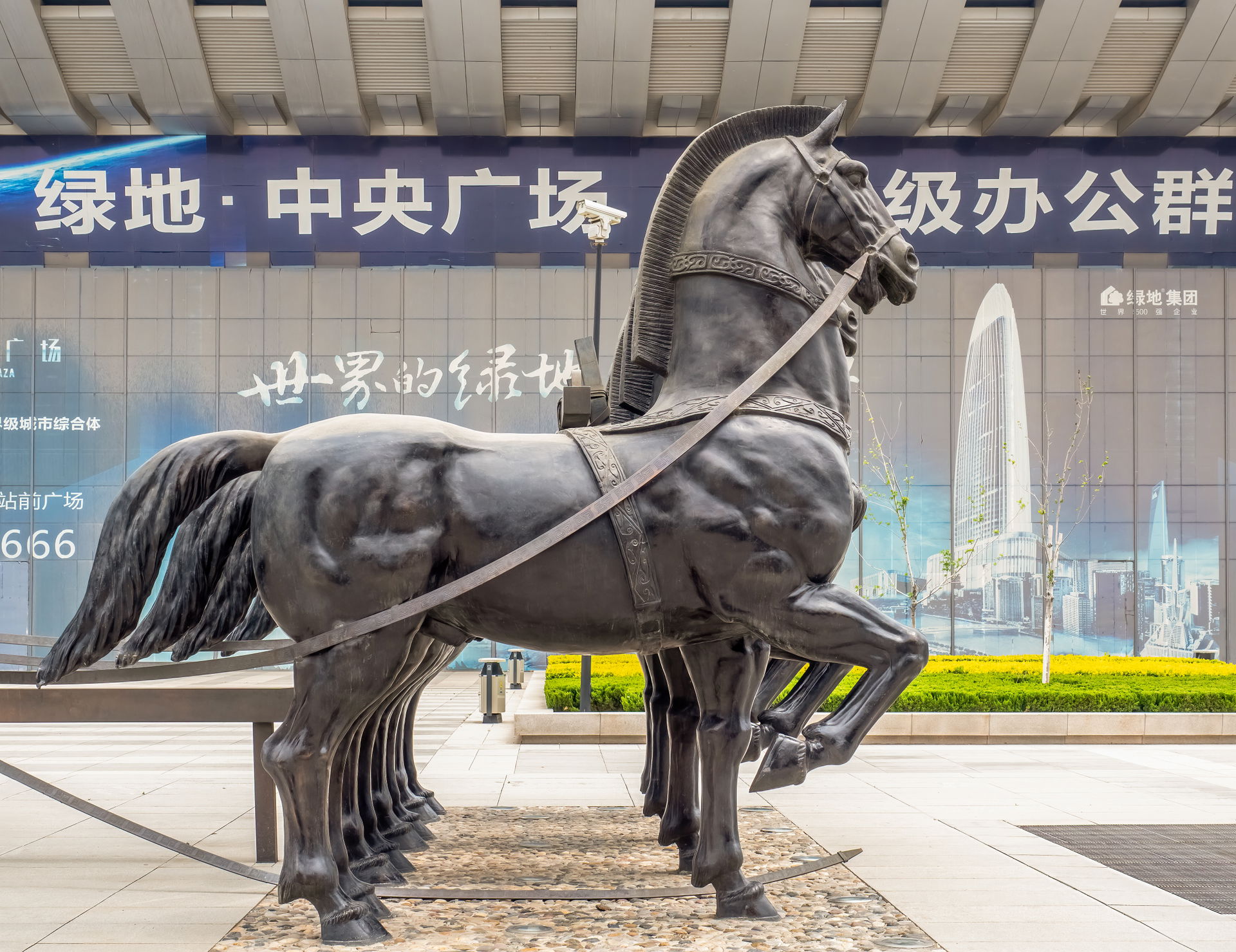 Bronze statues of horses at the entrances of a car park in Jina…