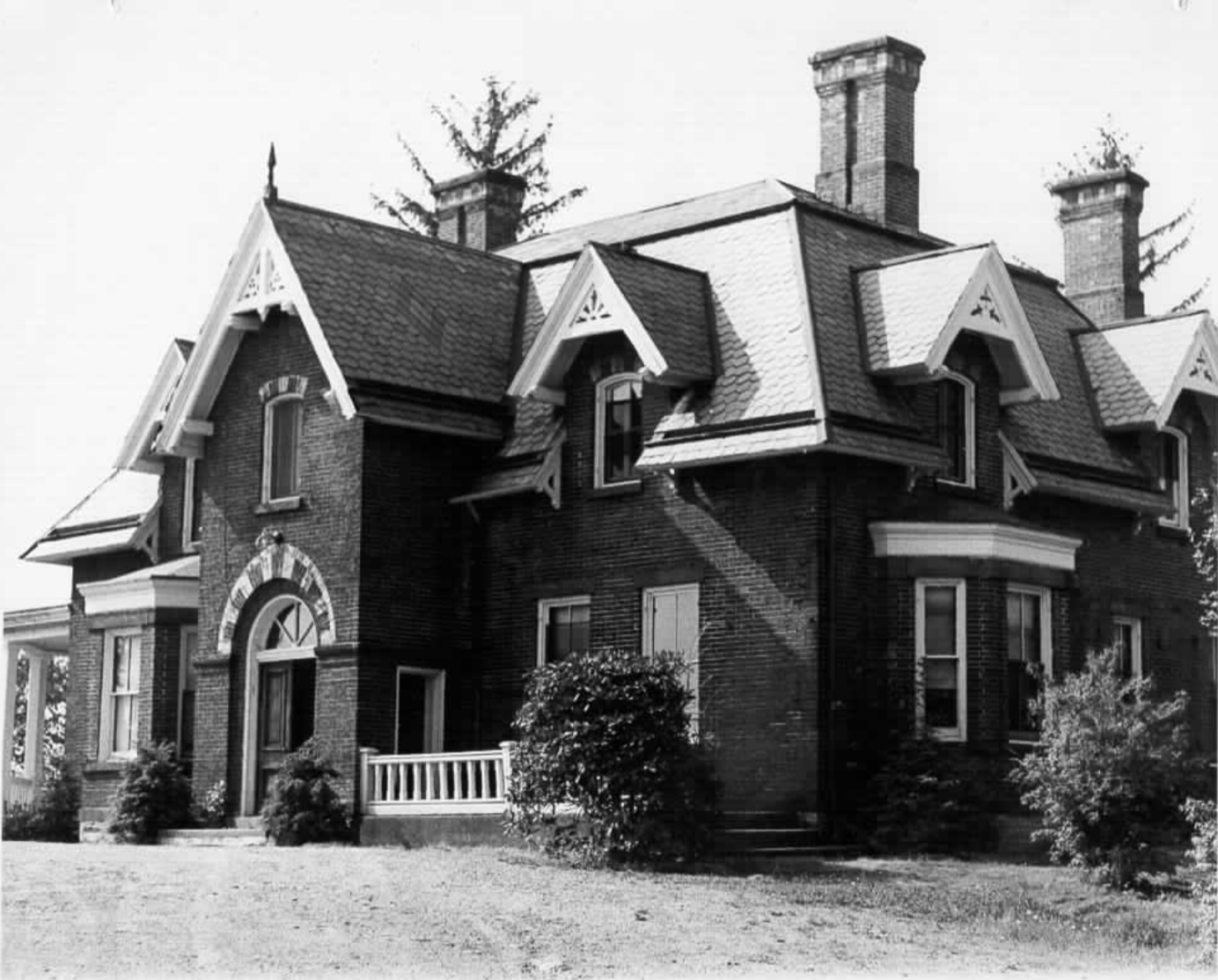 A red brick house built in the 1860s, viewed from an angle belo…