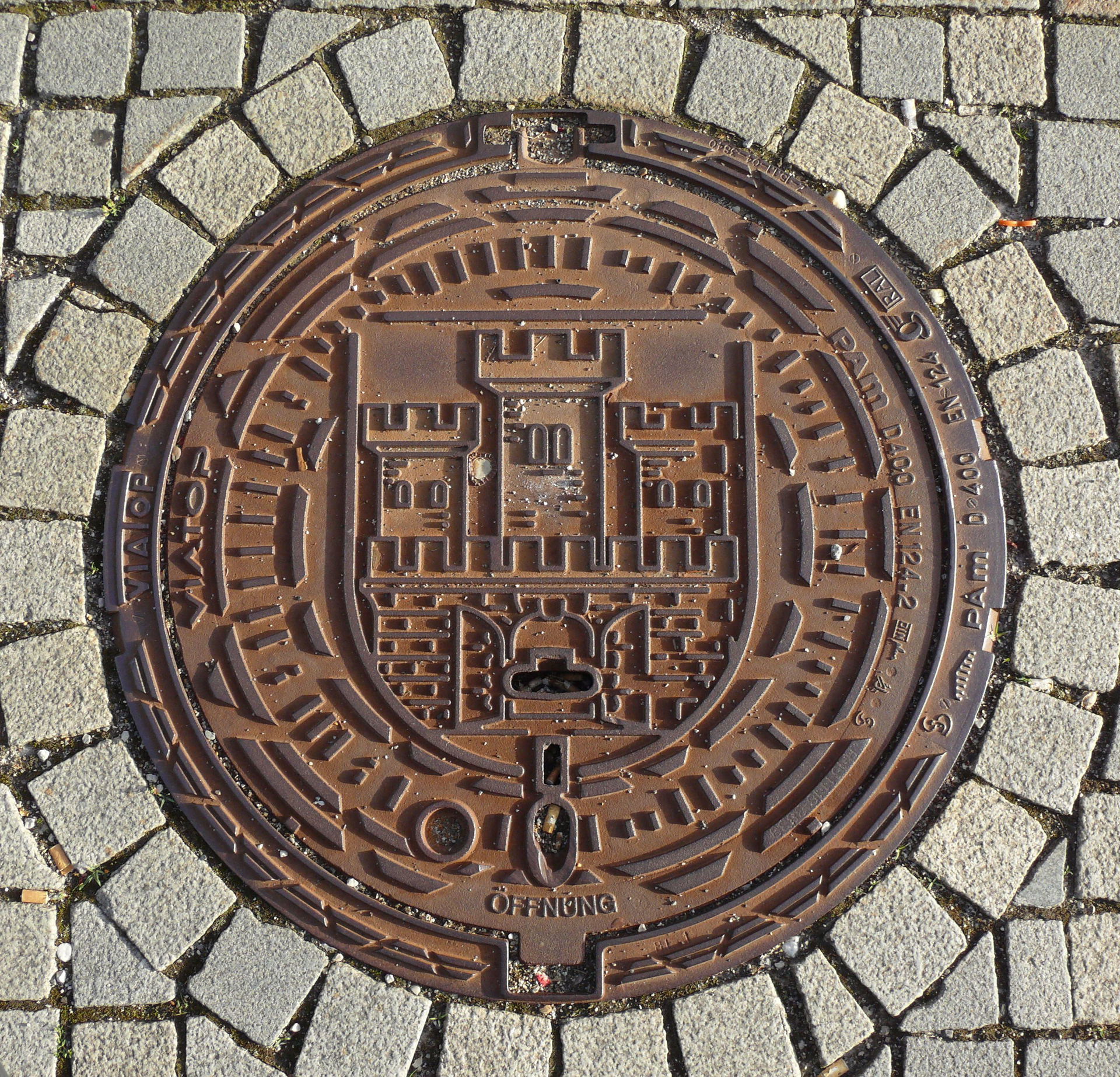 Weilheim, Marienplatz: Kanaldeckel mit dem Stadtwappen