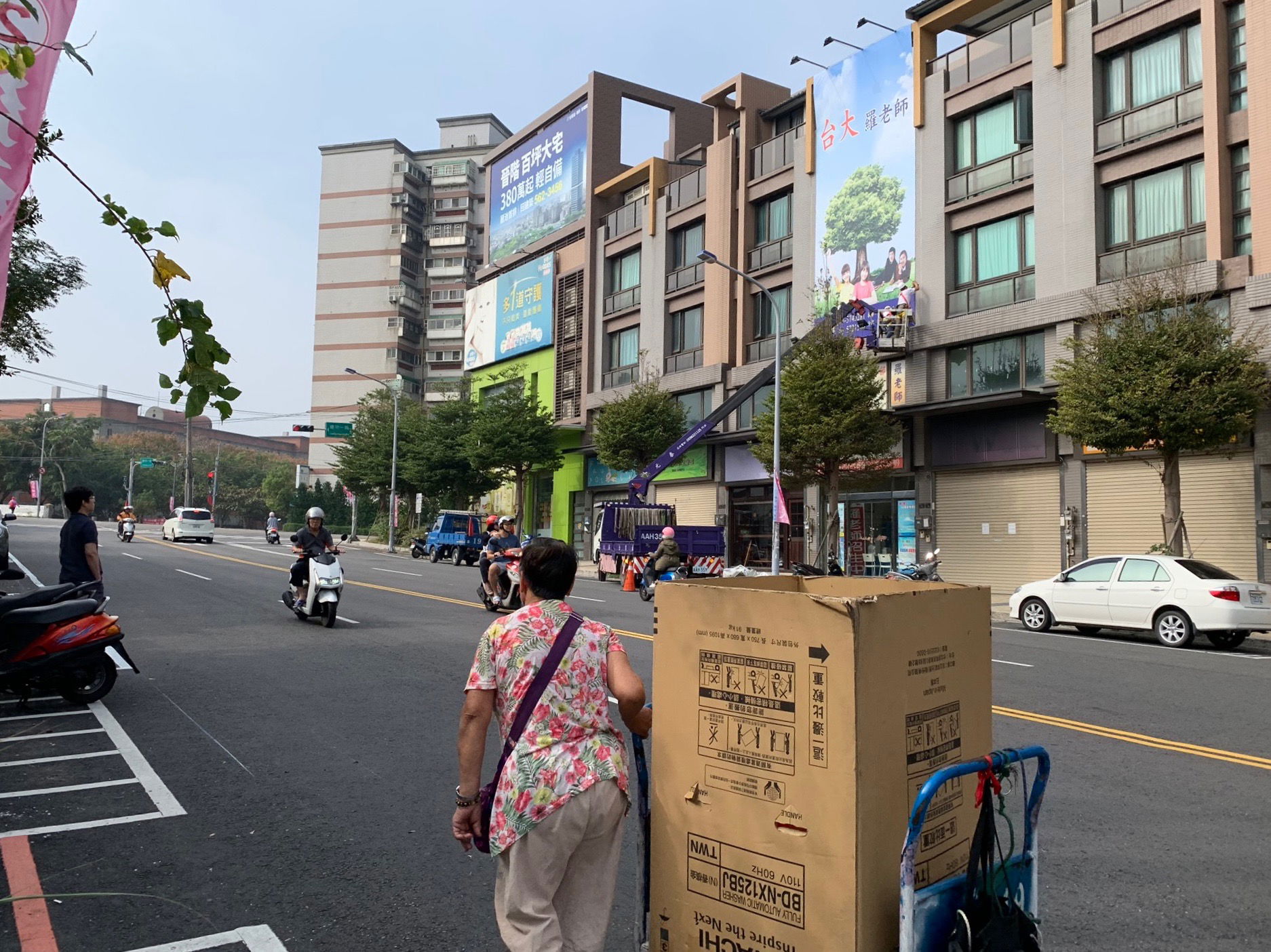 一位女性正手拉著載運回收物的推車。攝於新竹市建美路。