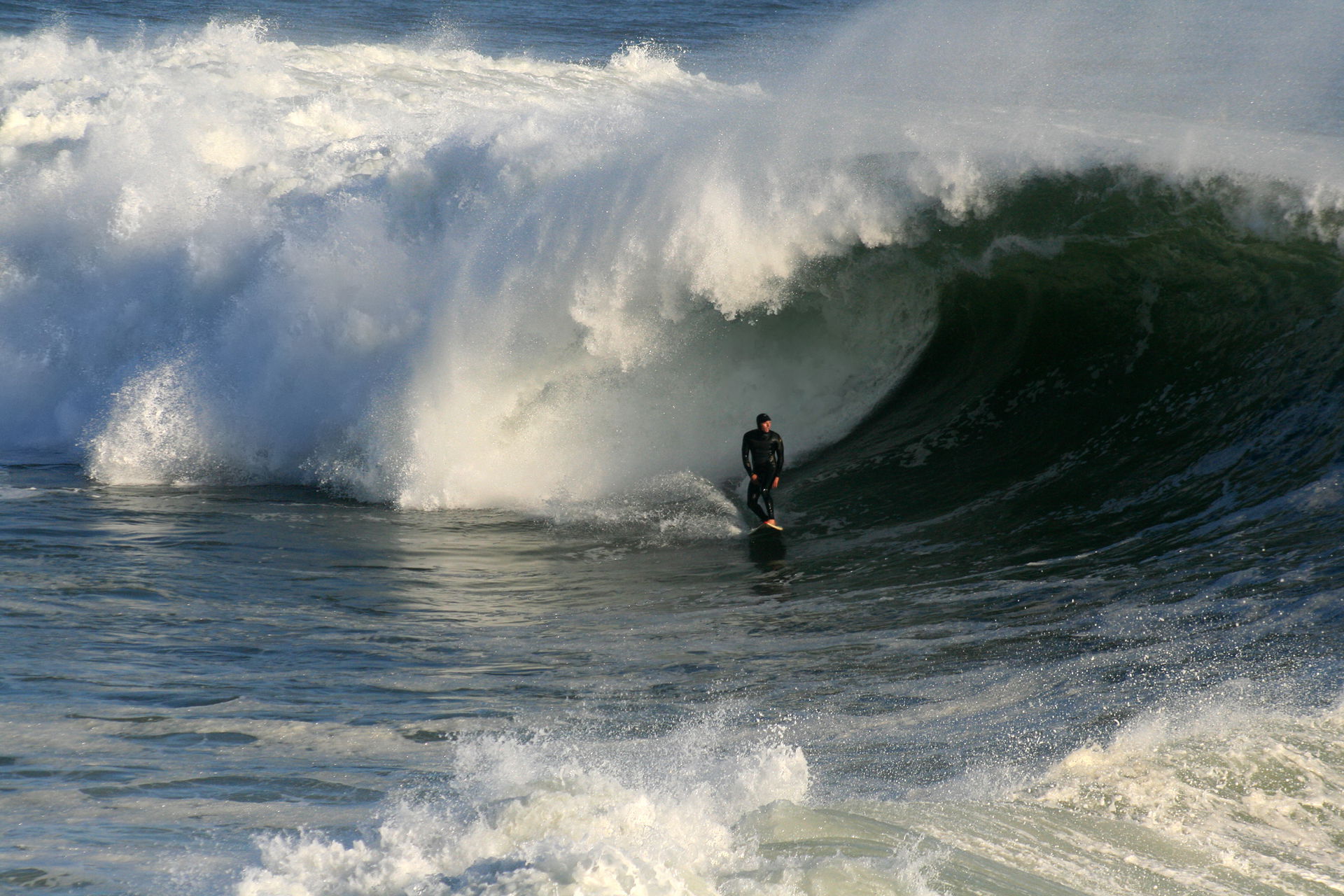 A big wave is breaking in Santa Cruz, California.