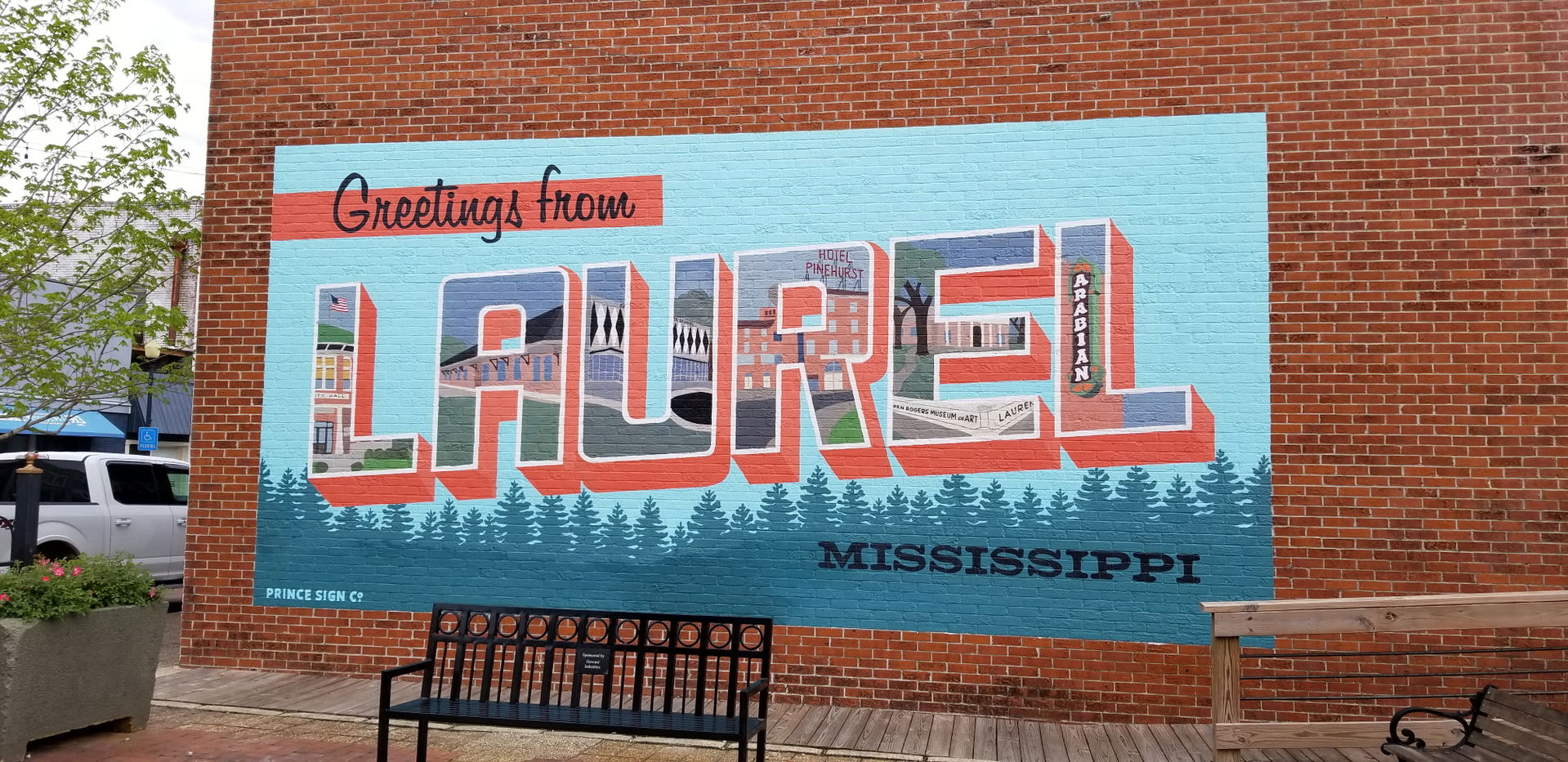 Brick wall bearing a painted sign that offers greeting, Laurel,…