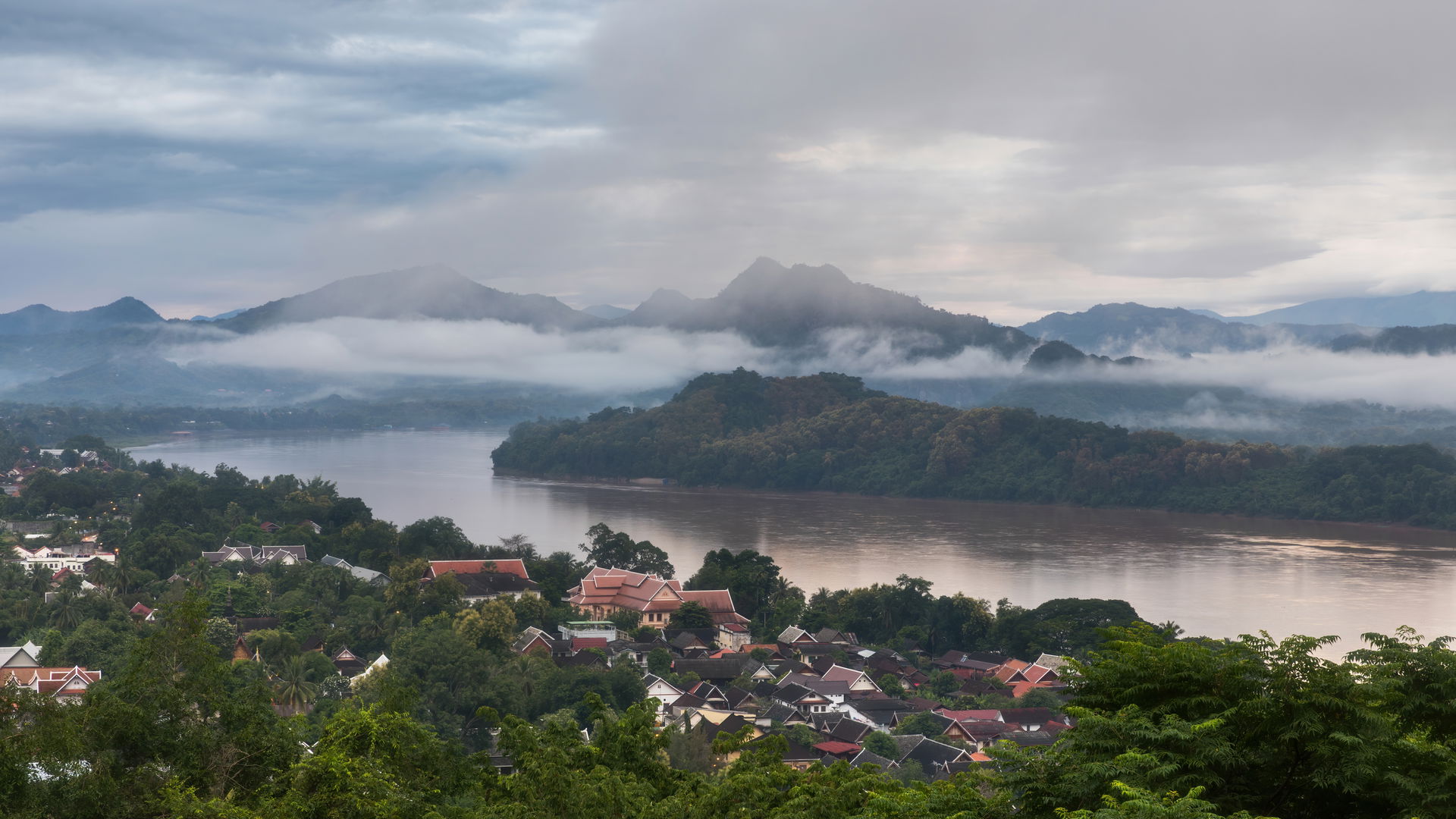 Mountains with fog and low clouds, muddy water of the Mekong ri…