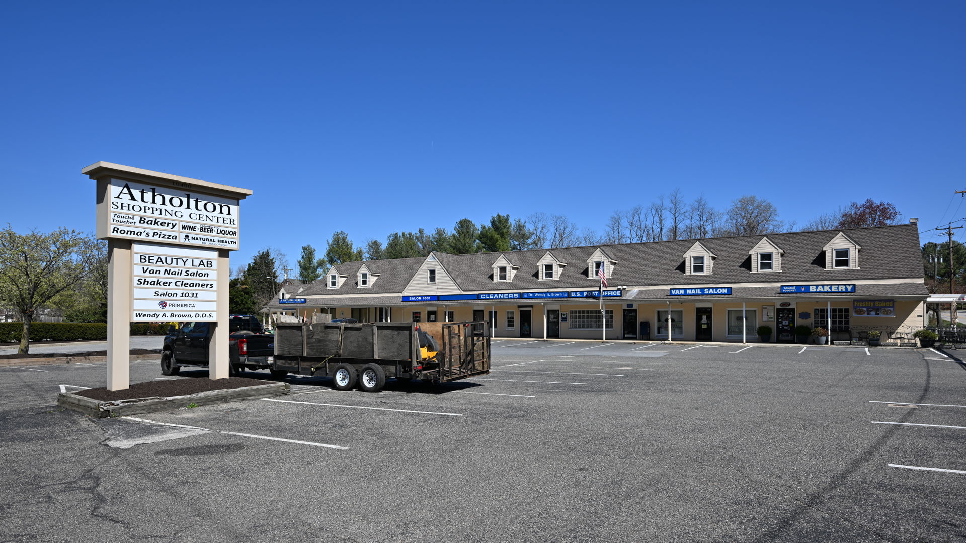 The sign, parking lot, and building of Atholton Shopping Center…