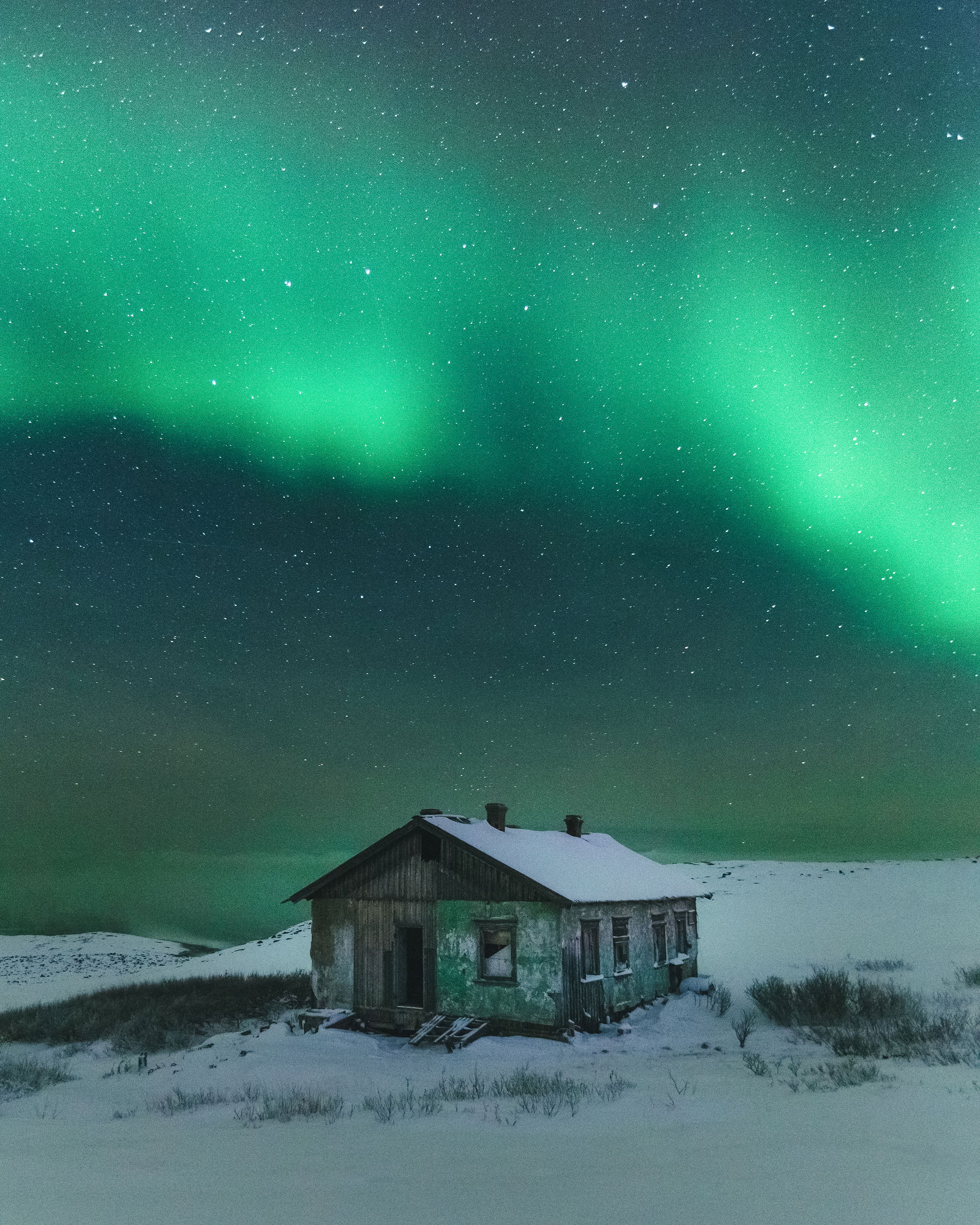 Northern lights over an abandoned building of weather station i…