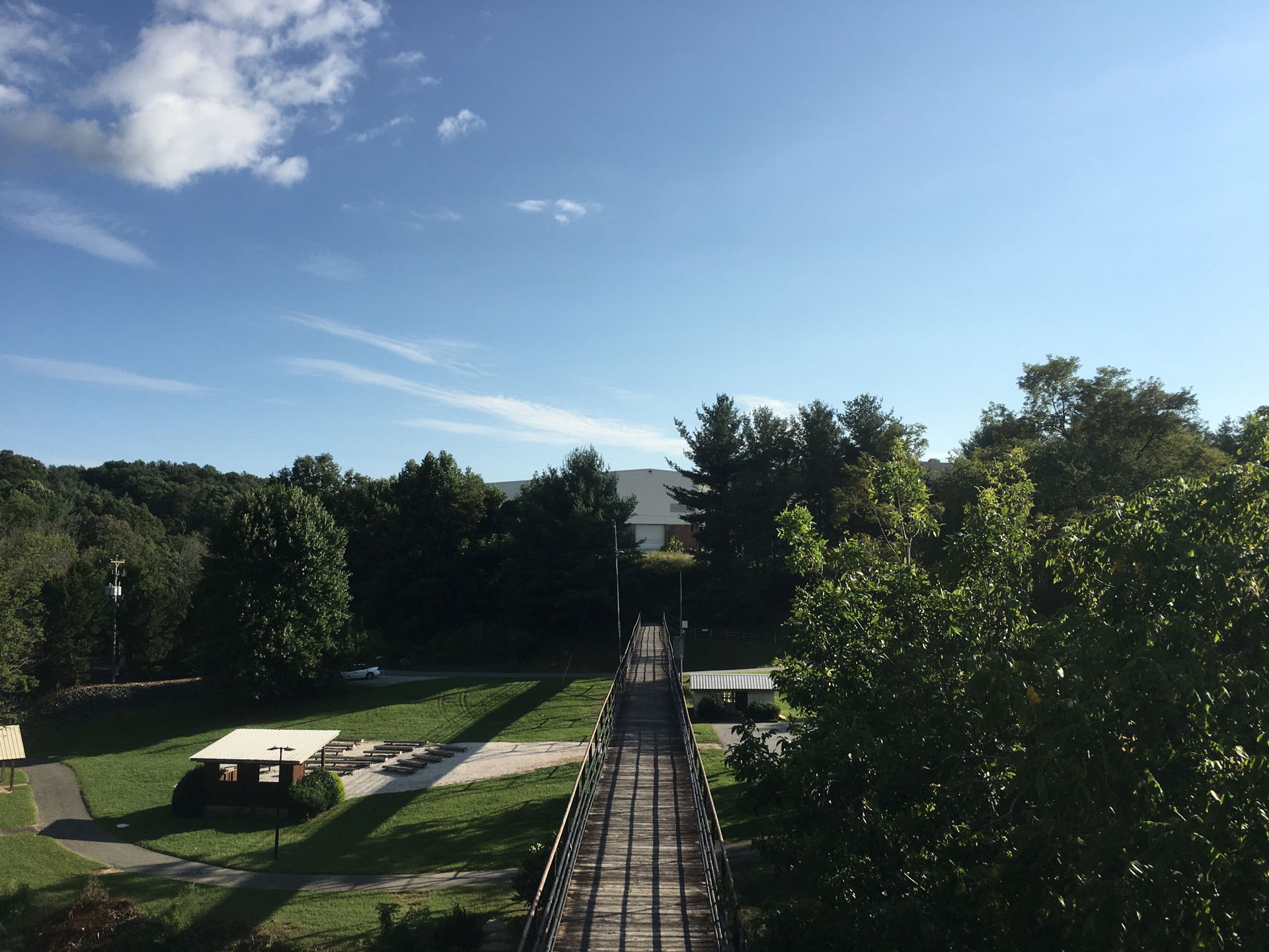 A wooden footbridge crosses above a public park in Spruce Pine,…
