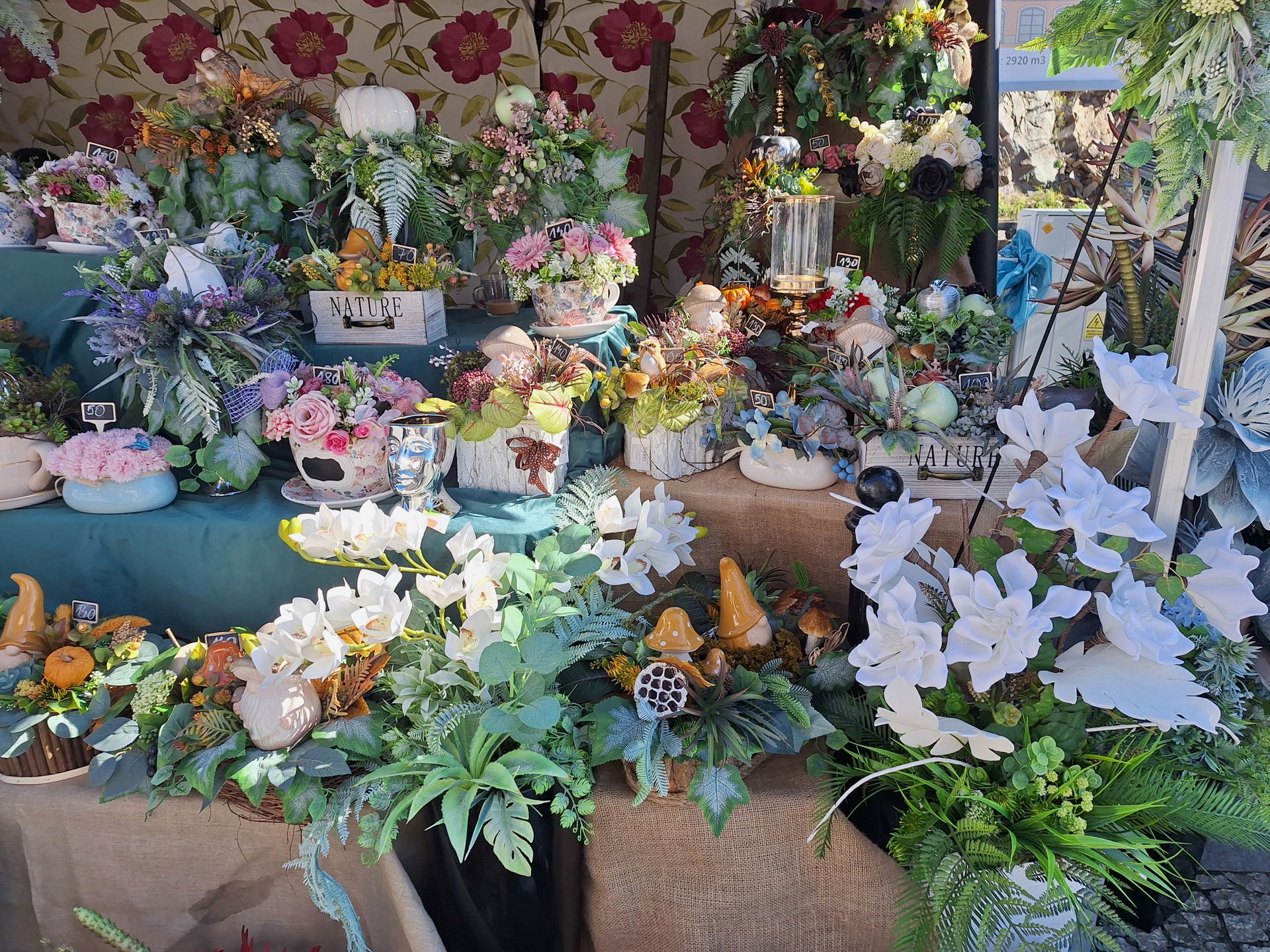 Market stall with artistic flower and plant arrangements at the…