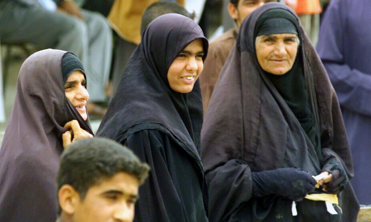 Three traditionally dressed women enjoy the day in the Iraqi Ci…