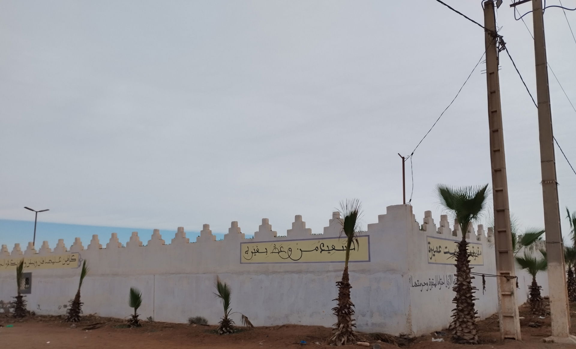 The cemetery's wall surrounded by palms trees at Ait Amira's ce…