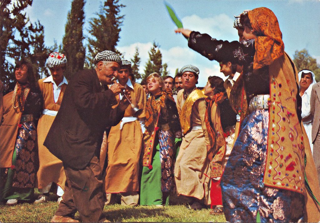 A photo of Assyrians dancing Chobi under the open blue sky of B…