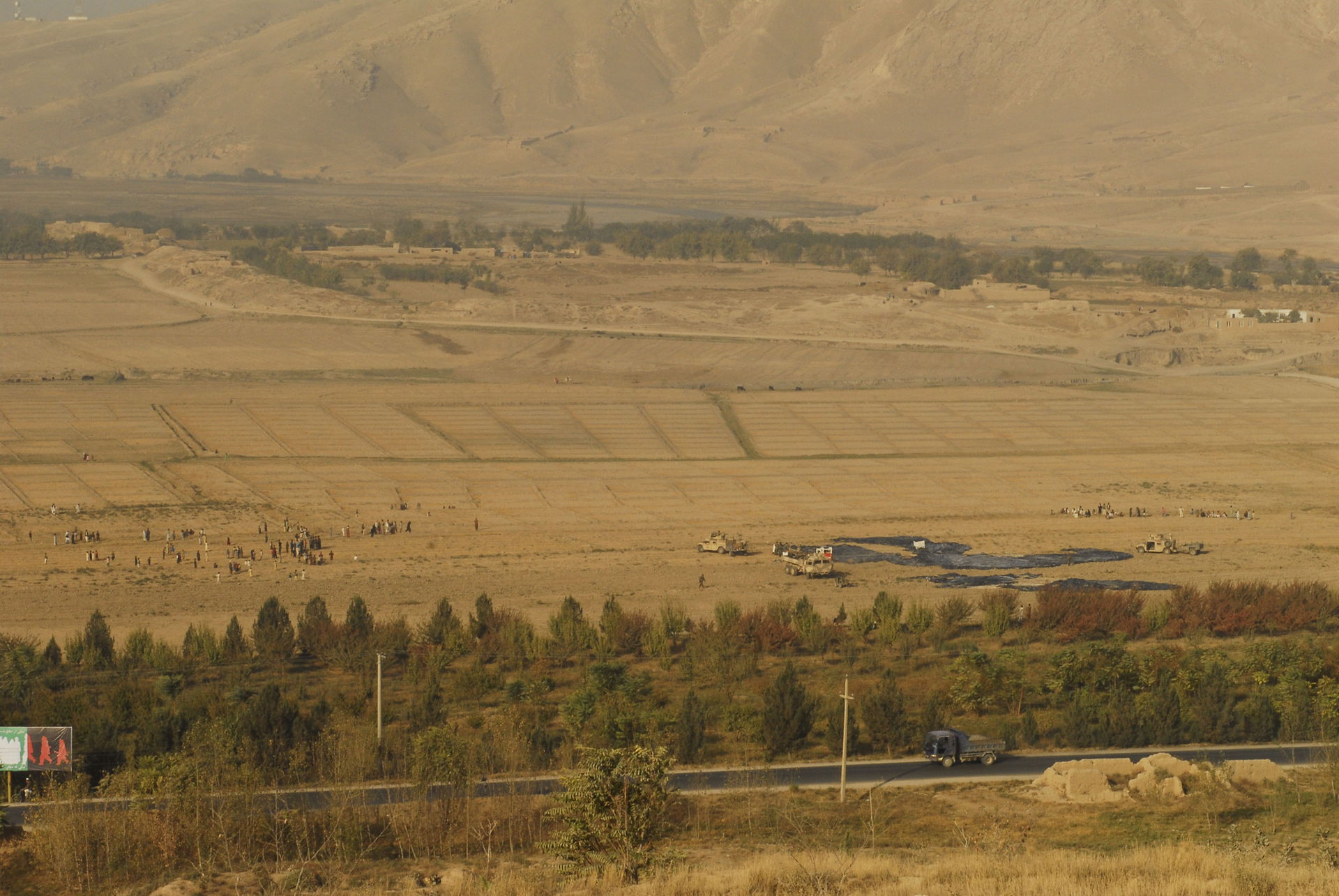 More than a hundred villagers gather, hoping to grab a parachut…
