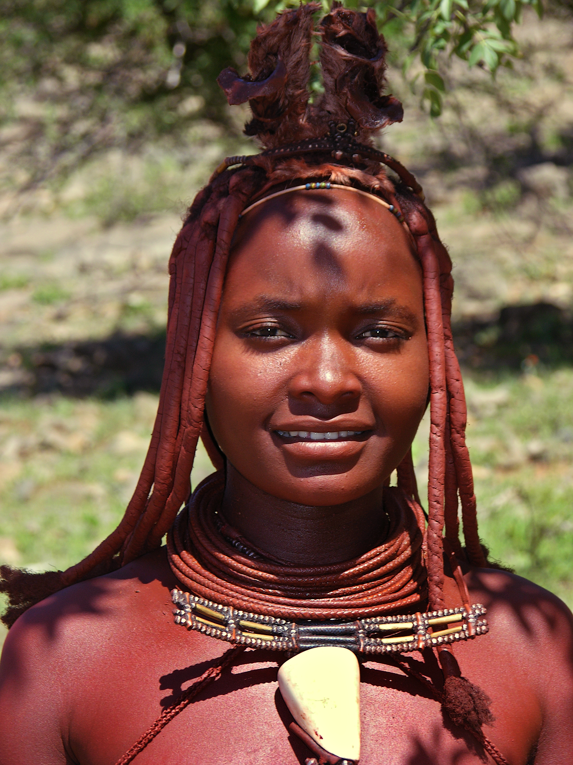 Himba Woman wearing traditional clothing and headdress, in a vi…