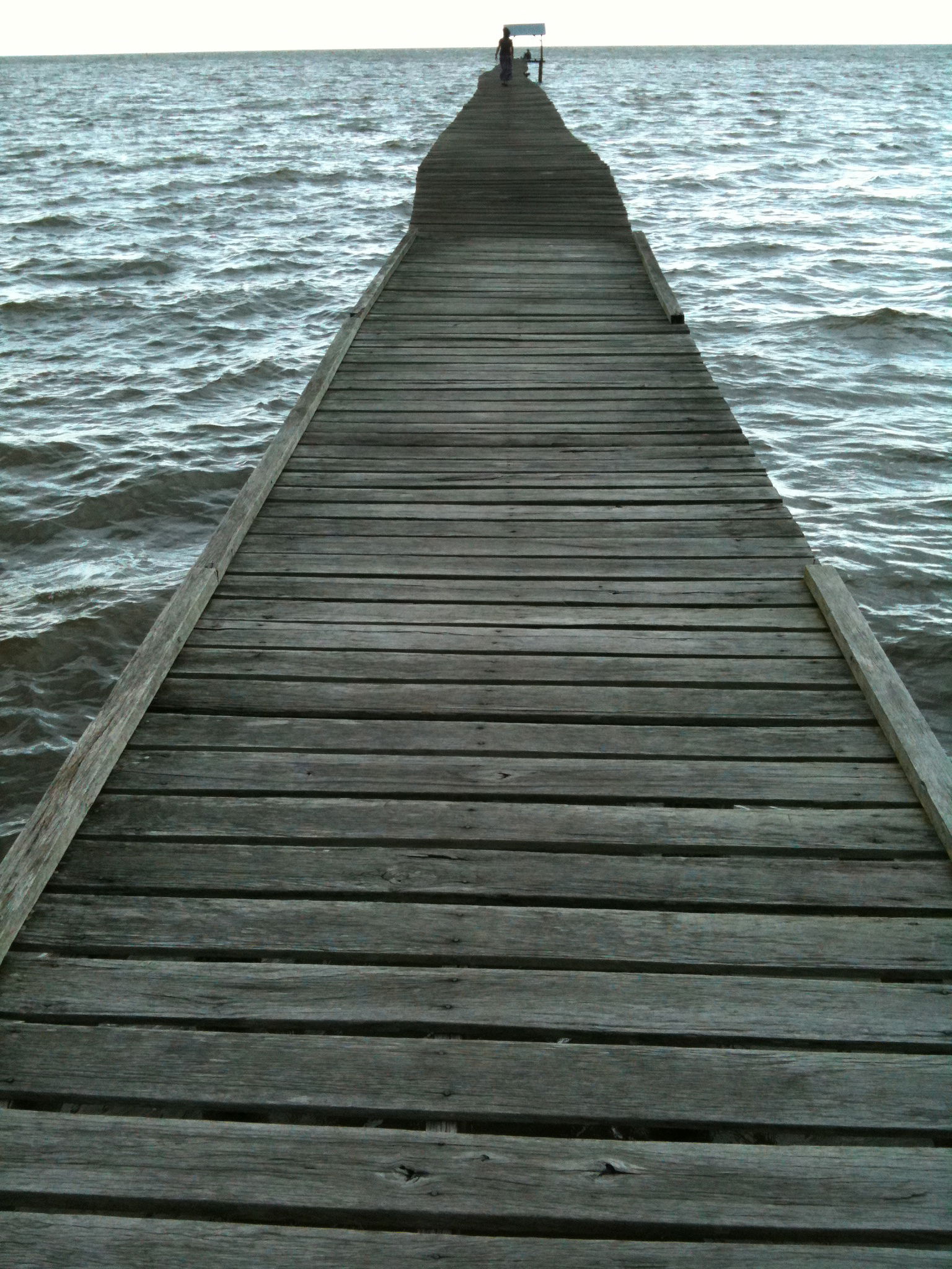 A long, wooden, narrow pier at pantai, Lawas