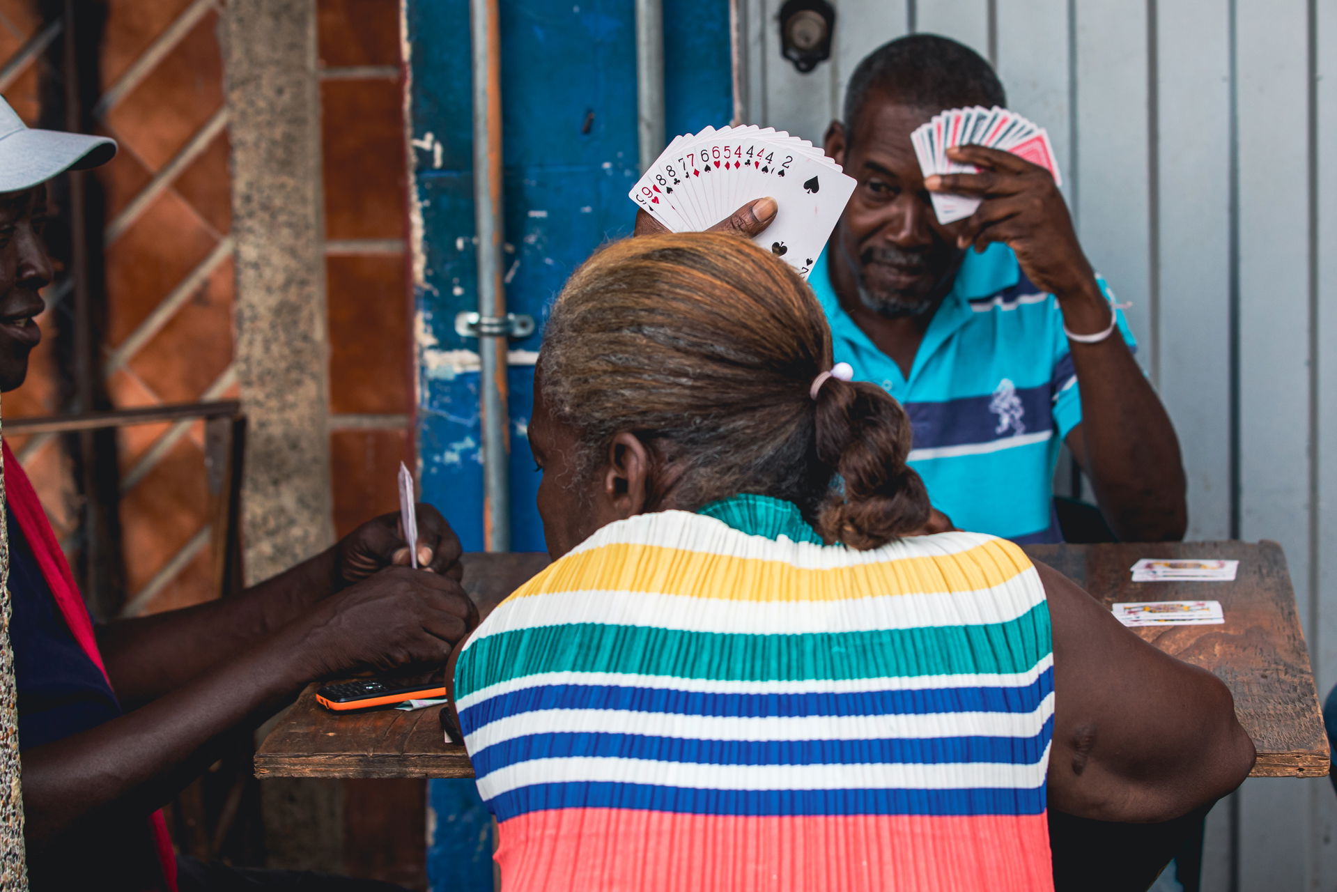 Two man and a women playing cards in Quibdó, Colombia