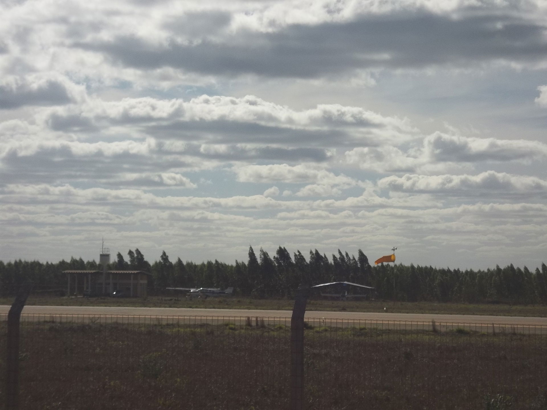 Aeroporto, visto por detrás das grades que o cercam.