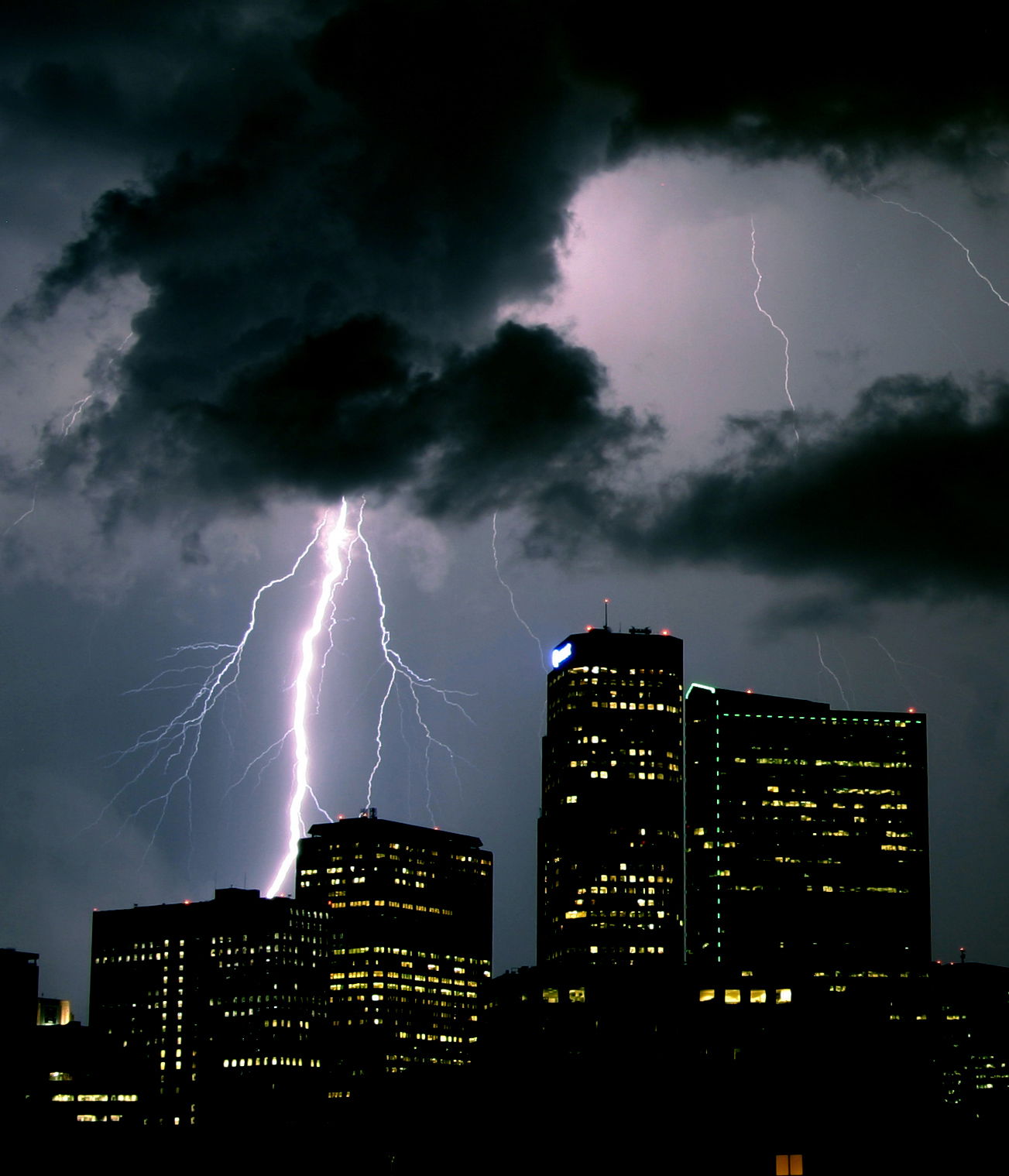 A large bolt strikes west of downtown Denver, with the west tow…
