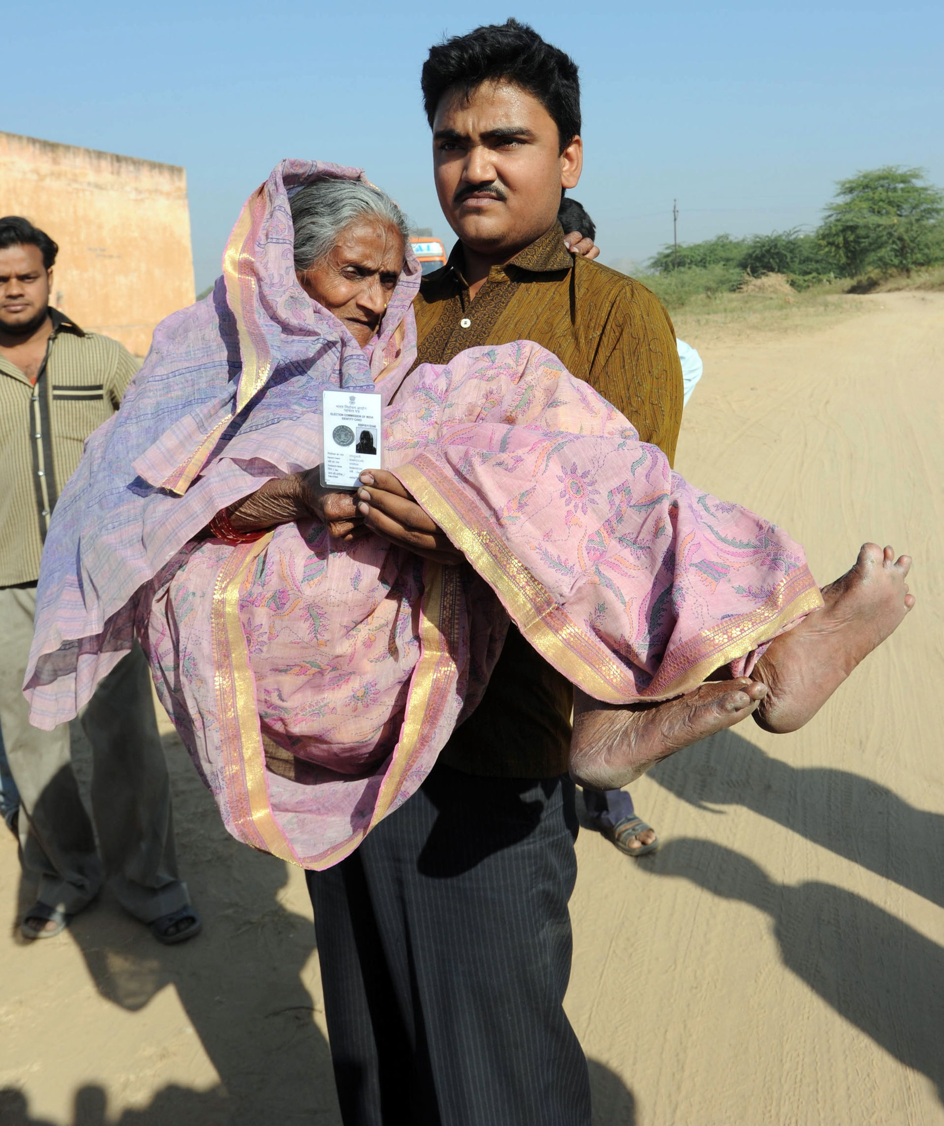 An elderly woman being carried to cast her vote at the polling …