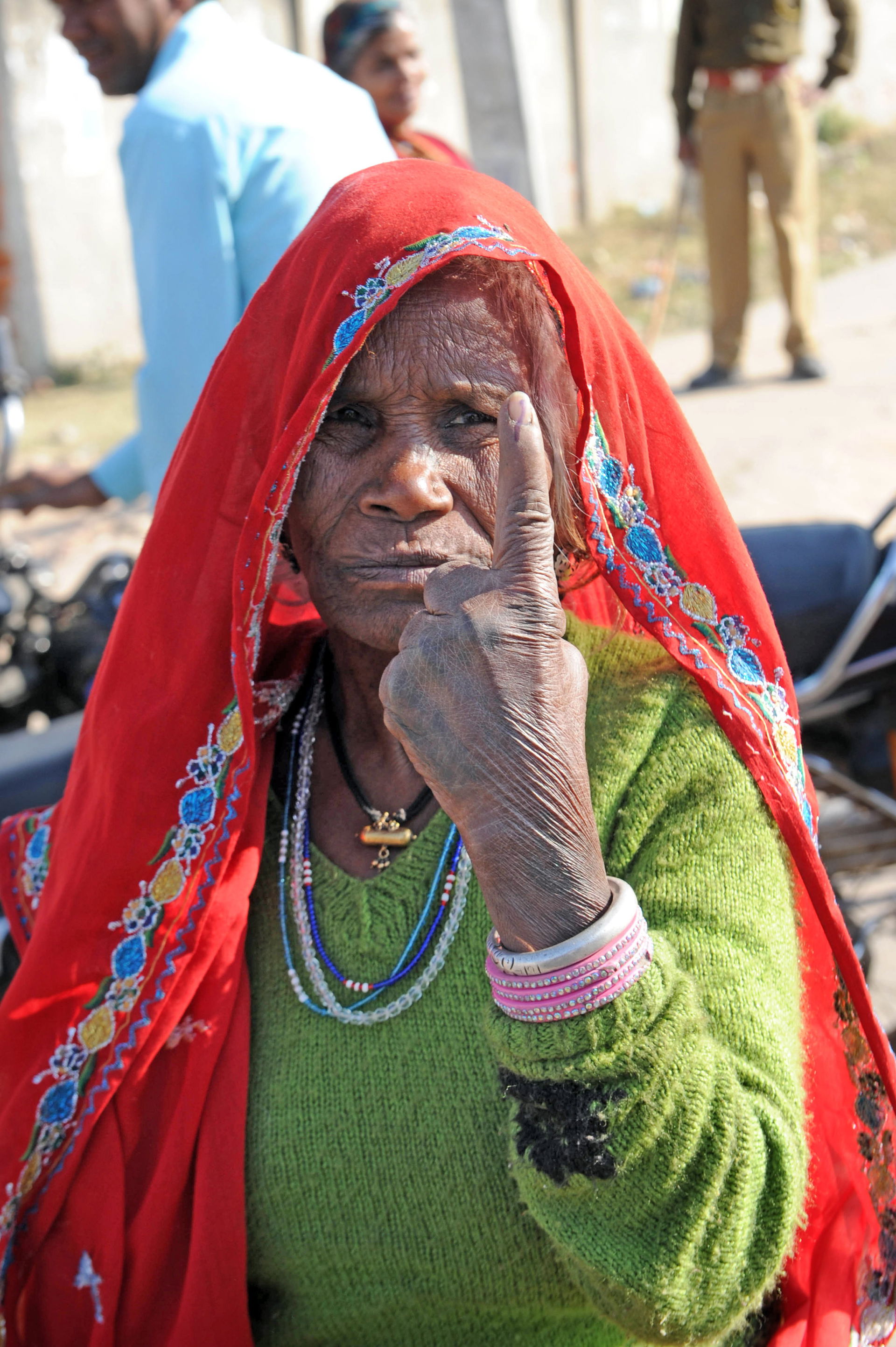 An elderly woman voter showing the ink-marked finger after cast…