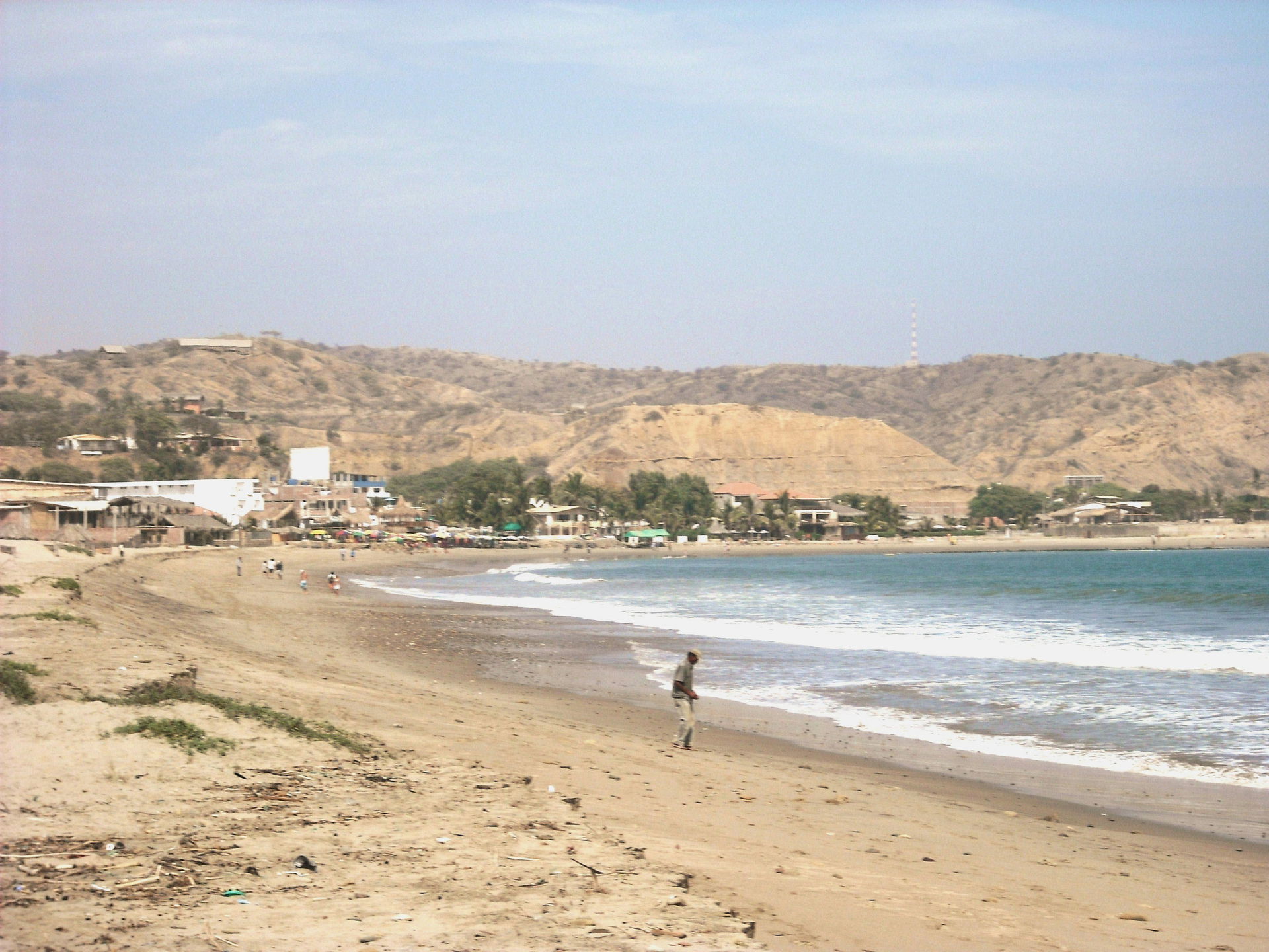 Máncora beach, the man in the middle is searching for coins dro…