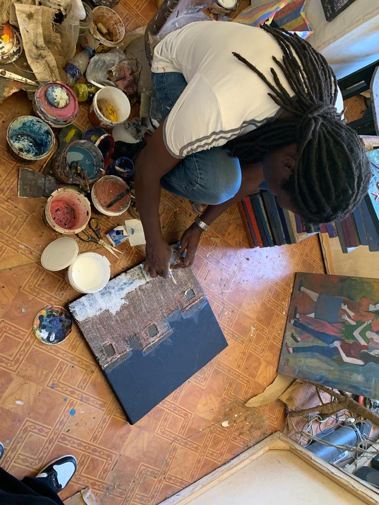 The artist uses ebony, jute bag and canvas to draw on the paint…