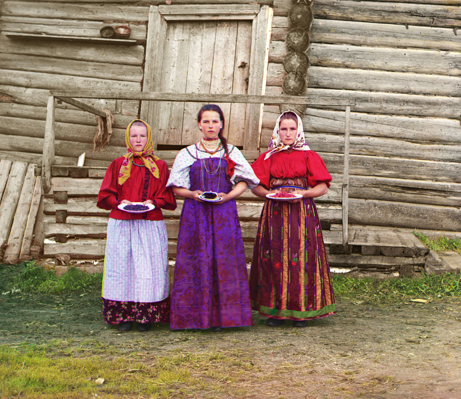 Young Russian peasant women in front of traditional wooden hous…