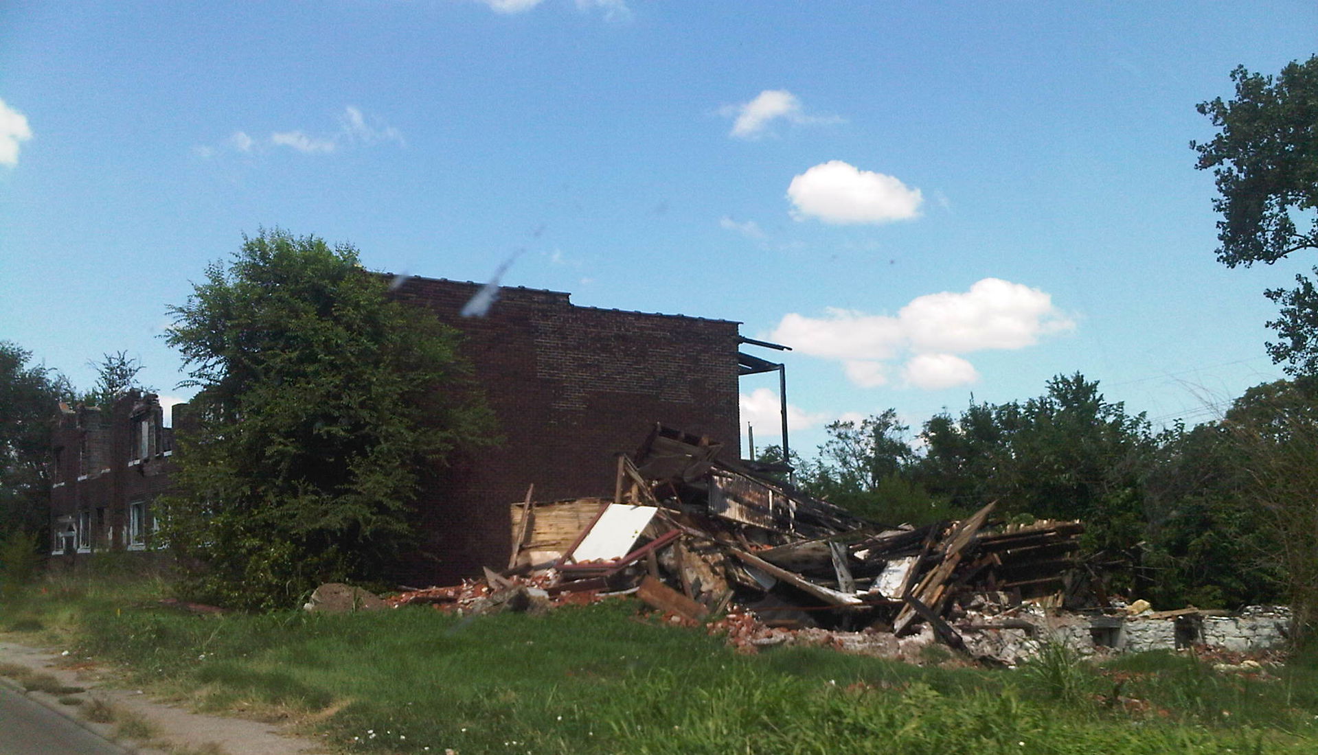 Severely damaged apartment building and a pile of debris along …