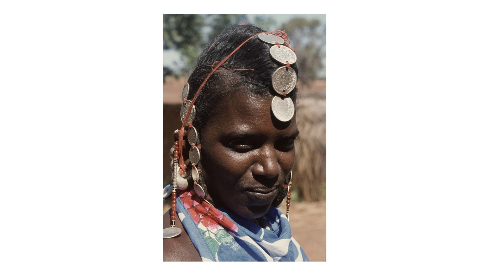 Portrait of a Fulani woman with a hairstyle full of coin jewelr…