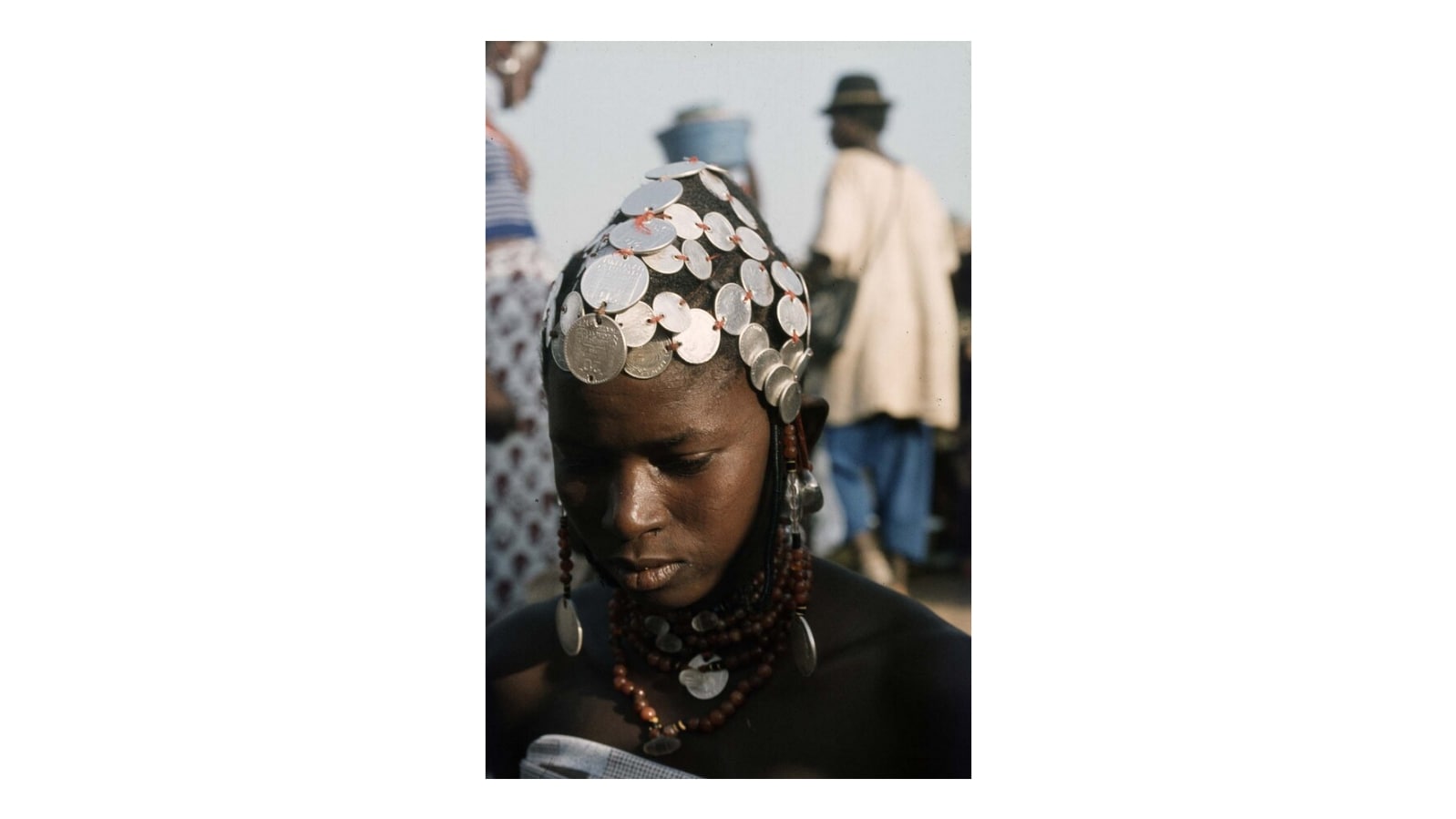 Portrait of a Fulani woman with a hairstyle full of coin jewelr…