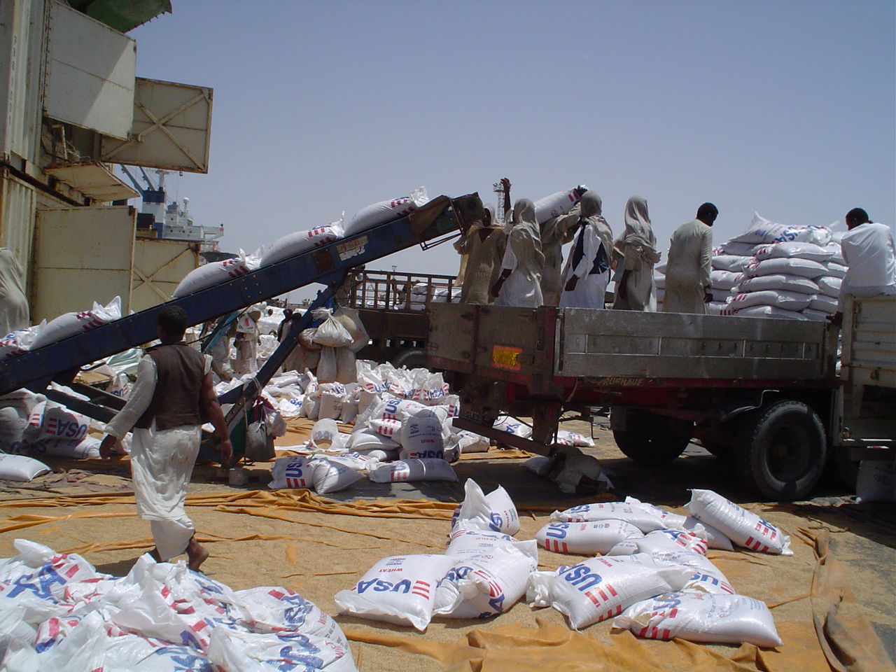 Caption: Offloading USAID wheat at Port Sudan – Bags of USAID-p…