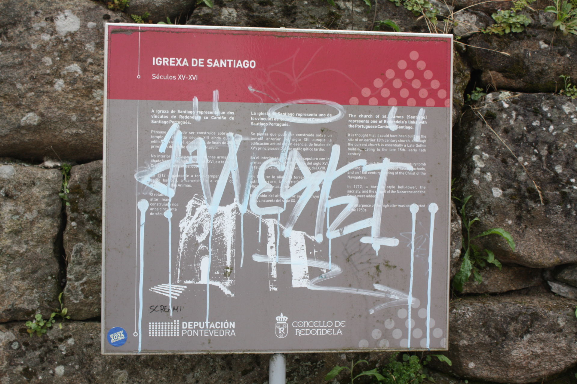 Cartel vandalizado ó pé da igrexa de Santiago, de Redondela (Po…