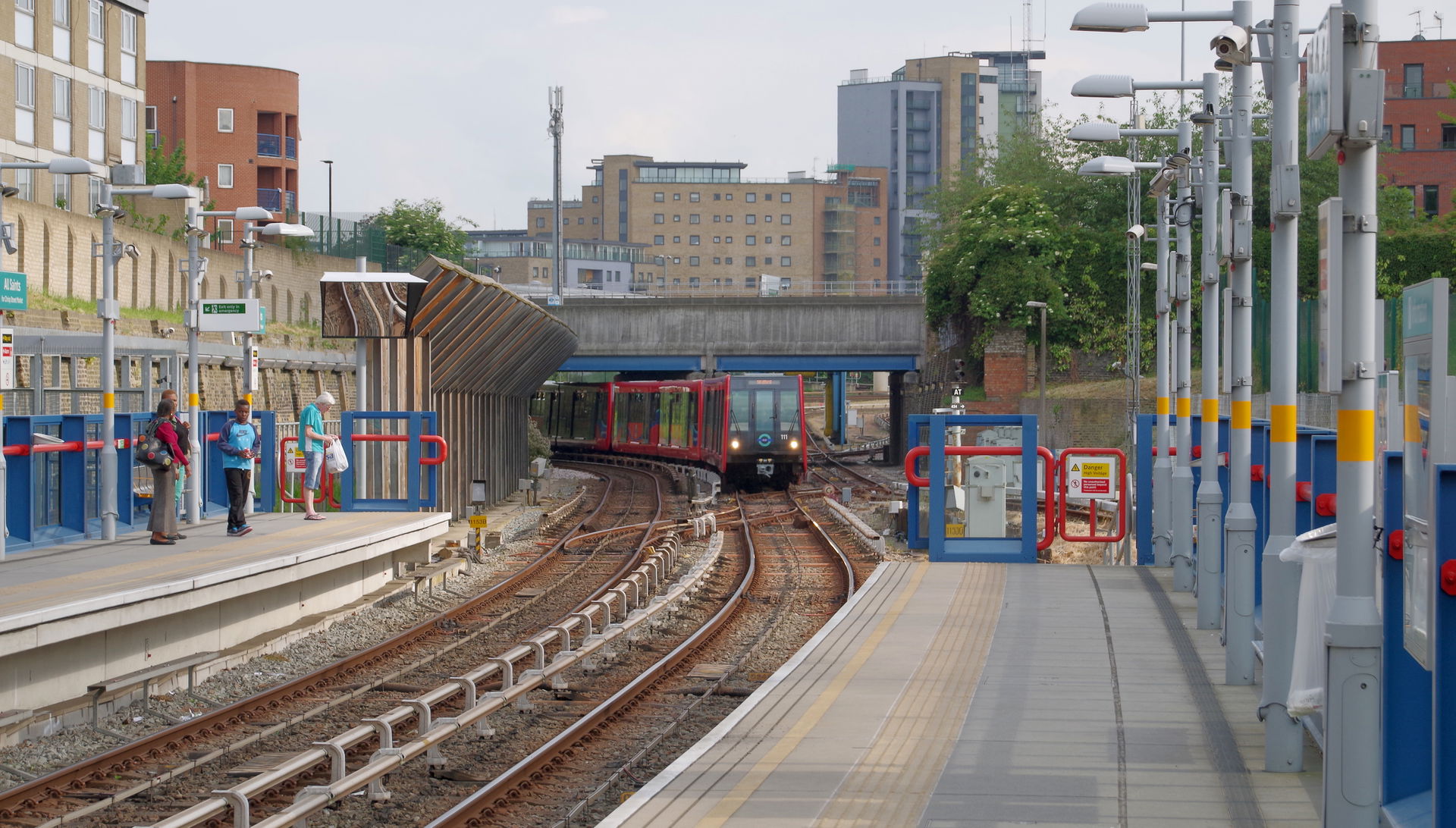 A DLR train of type B07 units, headed by 111, approaches All Sa…