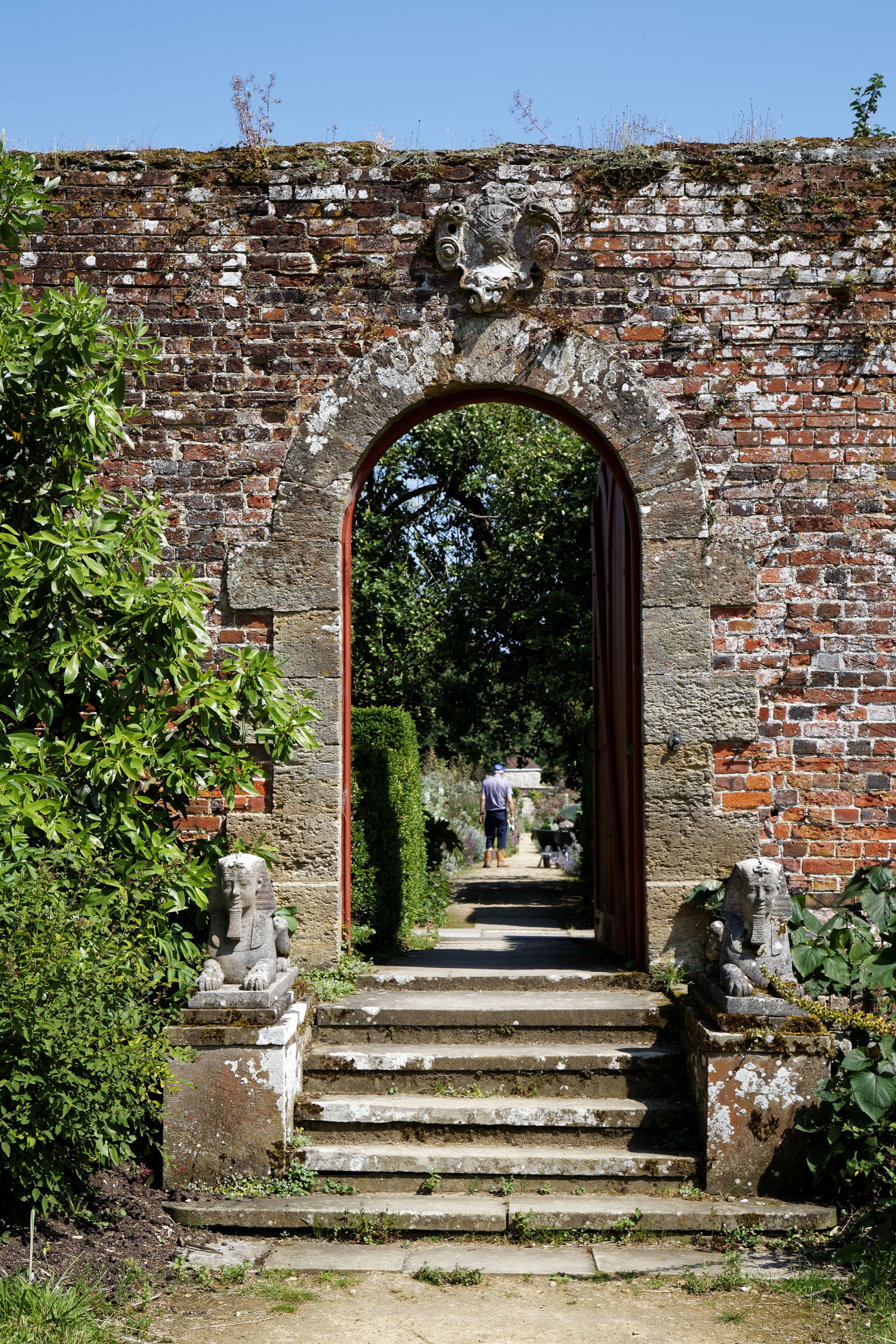 The lichen covered brick wall portal, gate and steps entrance f…