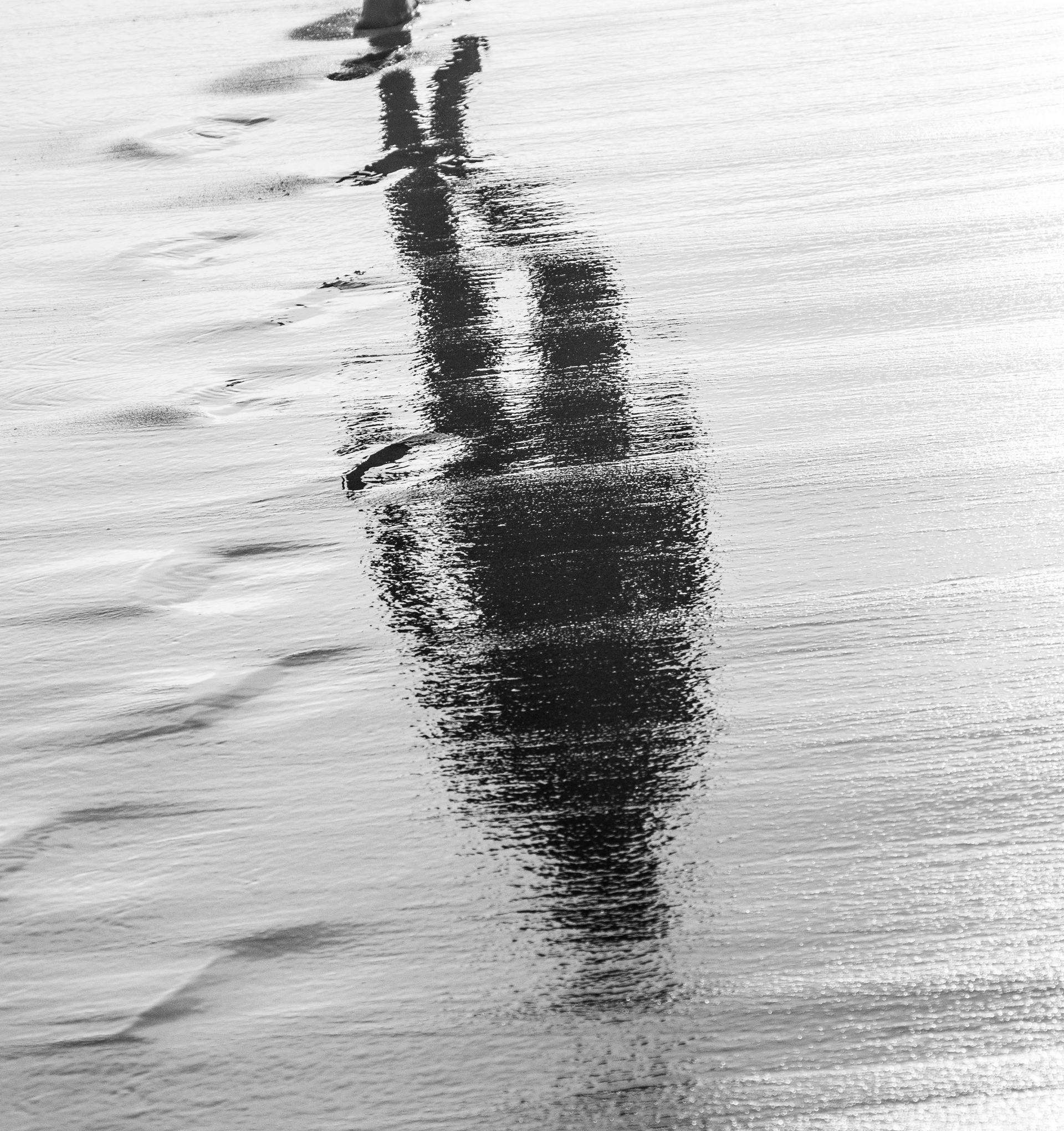 A reflection on sand and water.