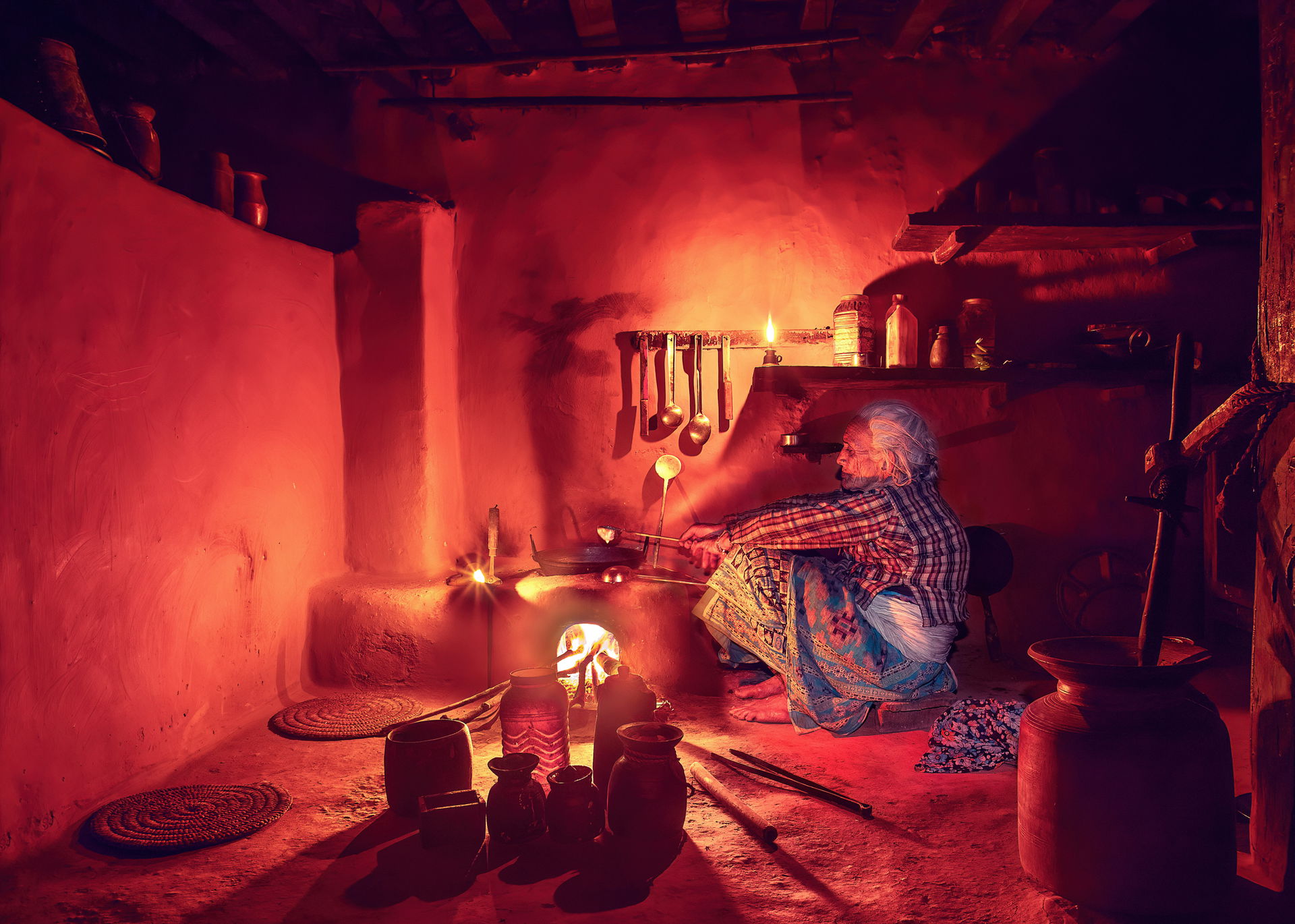 Nepalese grandmother while preparing food in a traditional kitc…