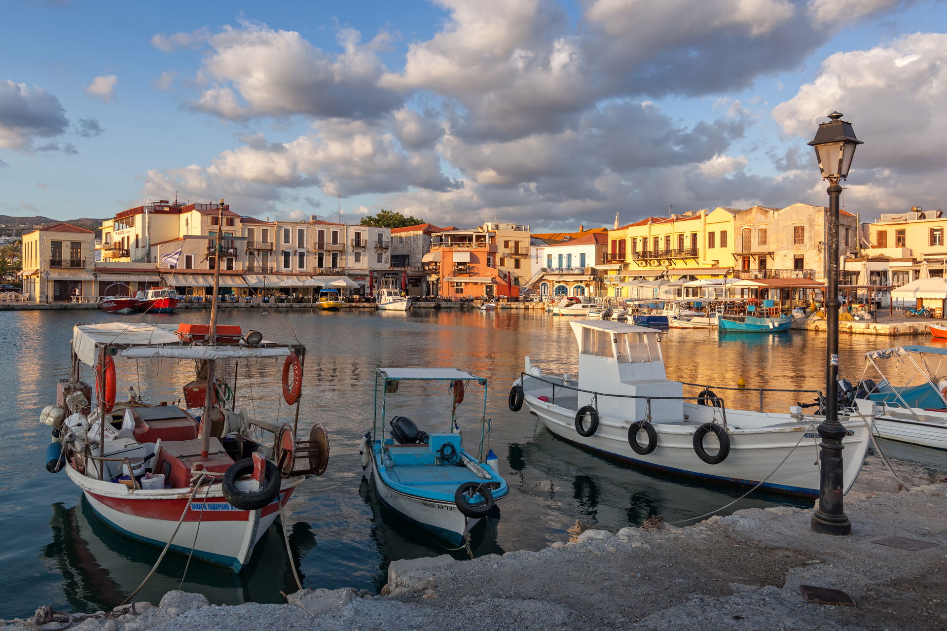 Rethymno old harbour with boats in front of restaurants at sunr…