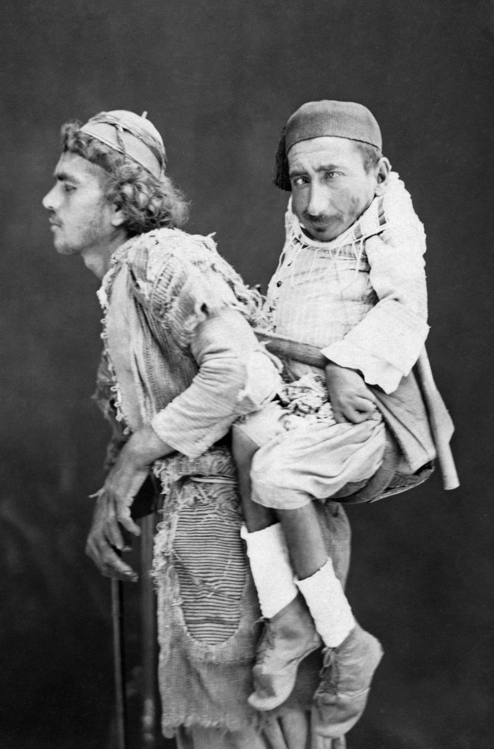 A blind man carrying a deformed man on his back in the Levant.