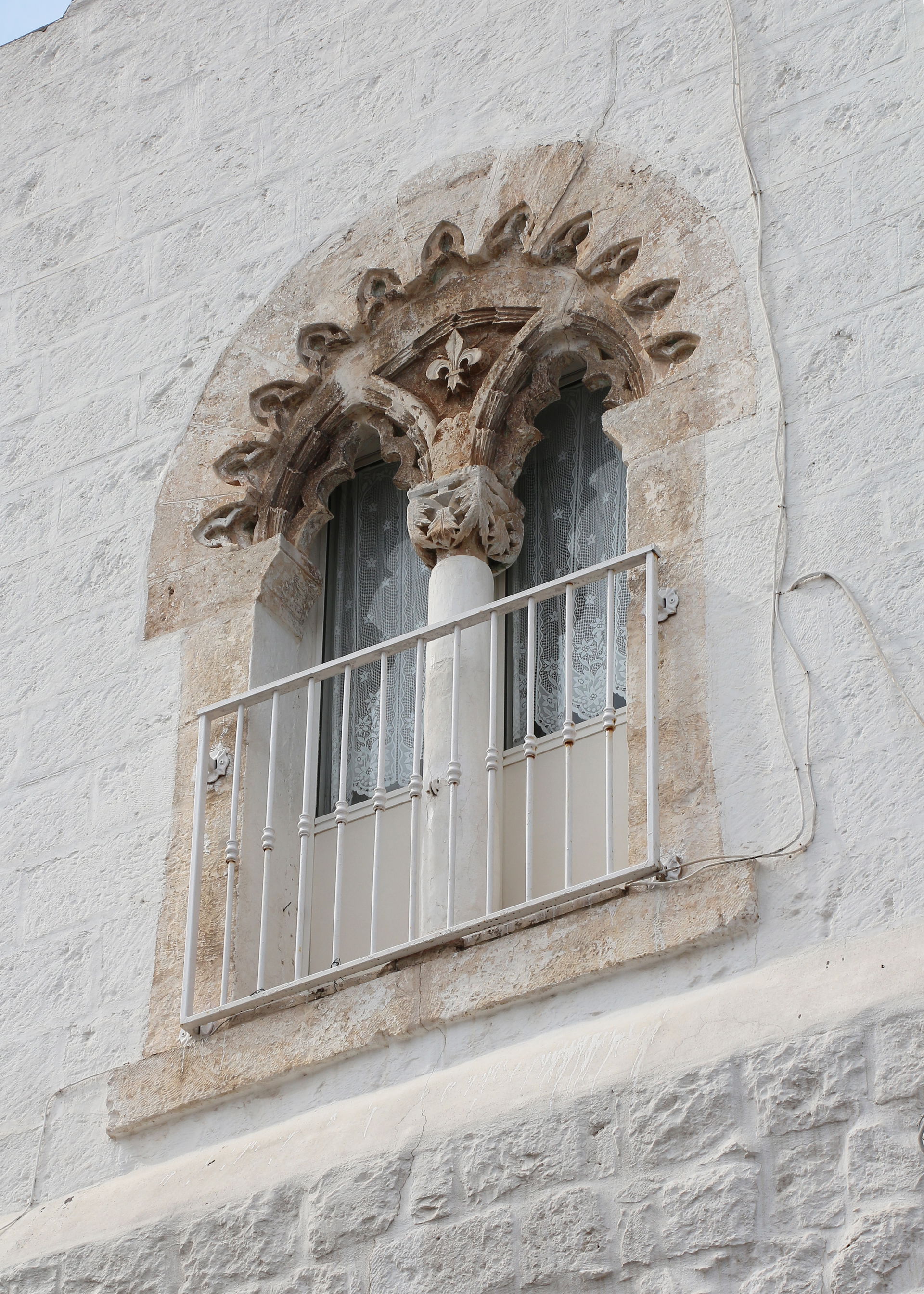 Trilobed geminated window on the fortifications of Ostuni, Italy