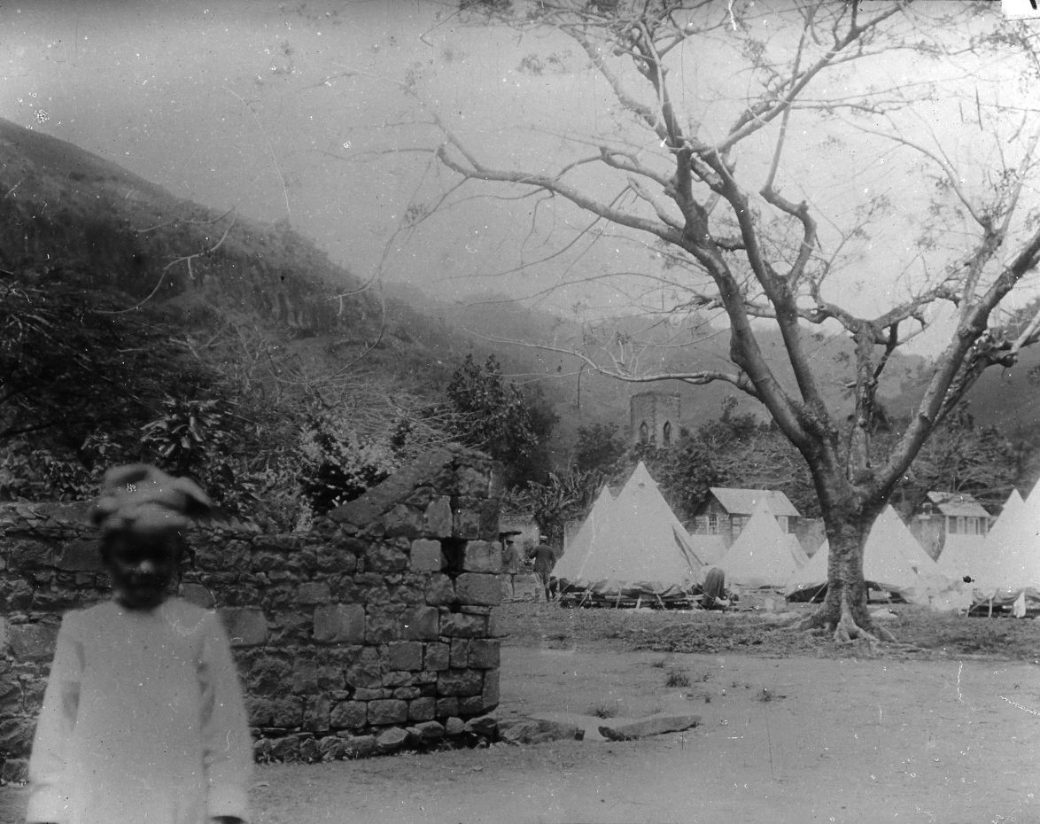 Group of tents and huts with hill behind. This is probably the …