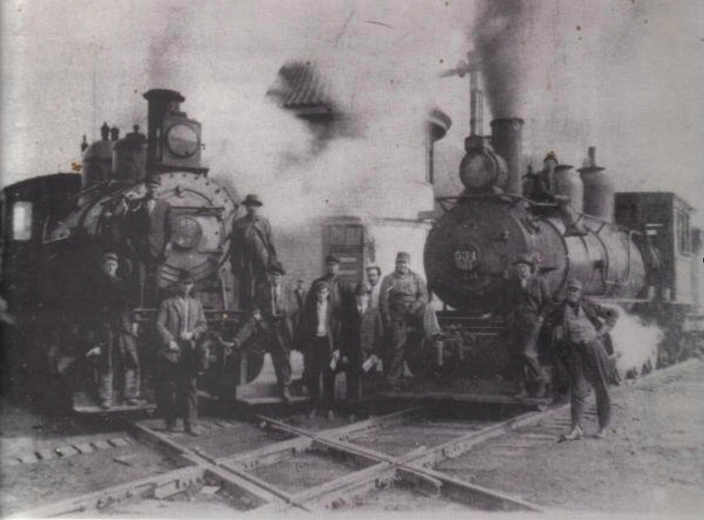 Photograph of 14 men, presumably workers of the railroad, stand…