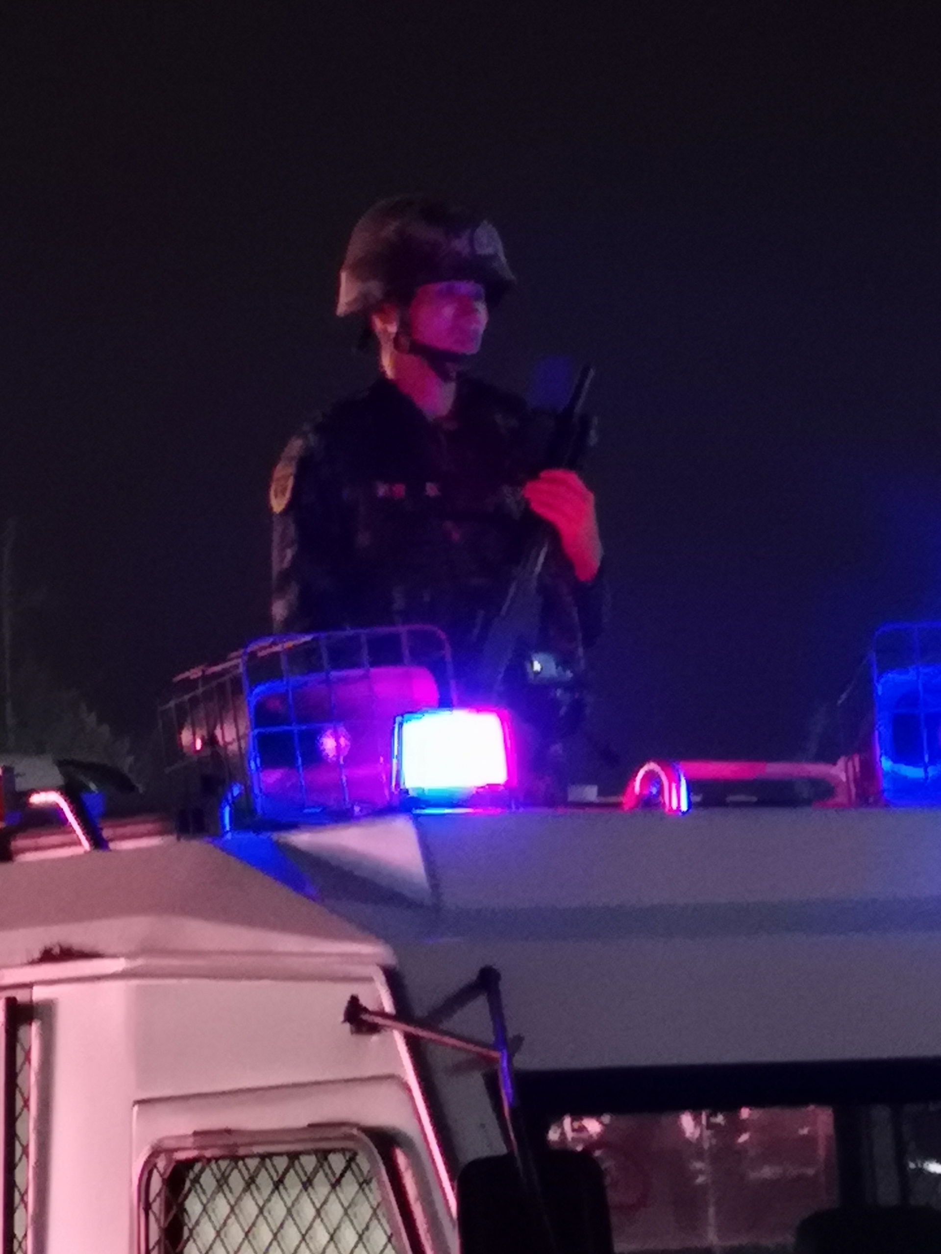 An armed Chinese policeman stands guard from a police vehicle w…