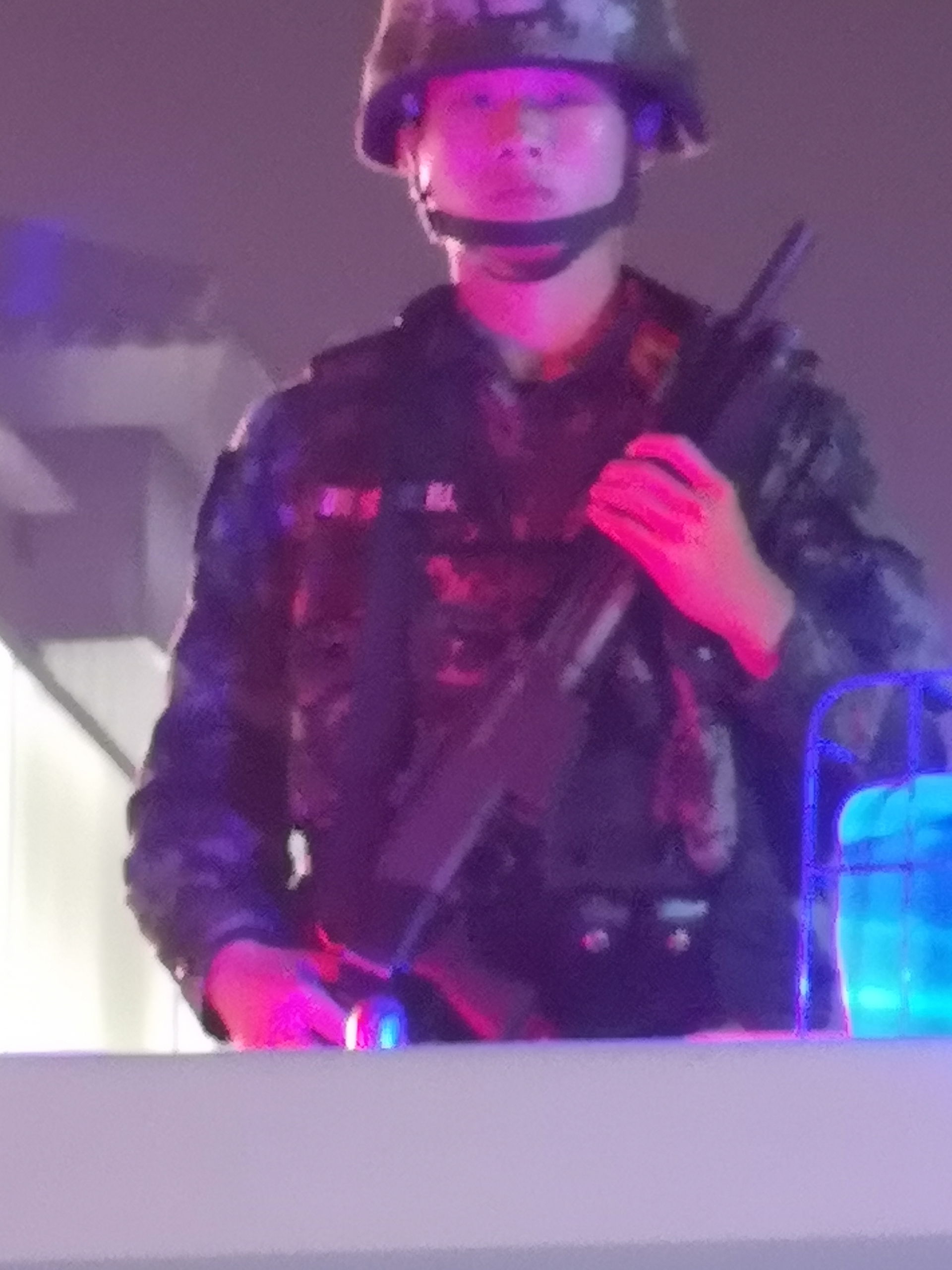 An armed Chinese policeman stands guard from a police vehicle w…