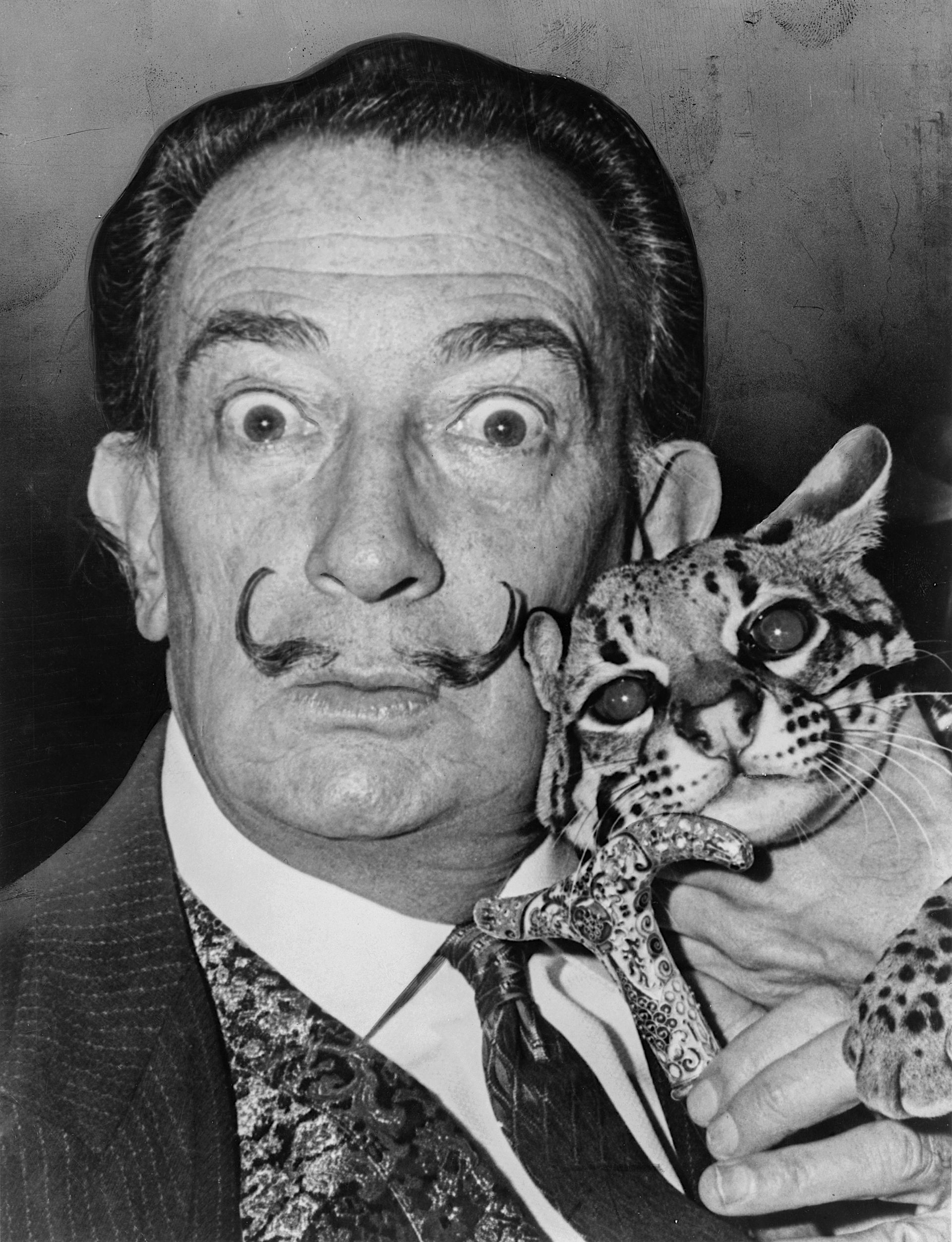 Salvador Dali with his pet ocelot, Babou, and cane.