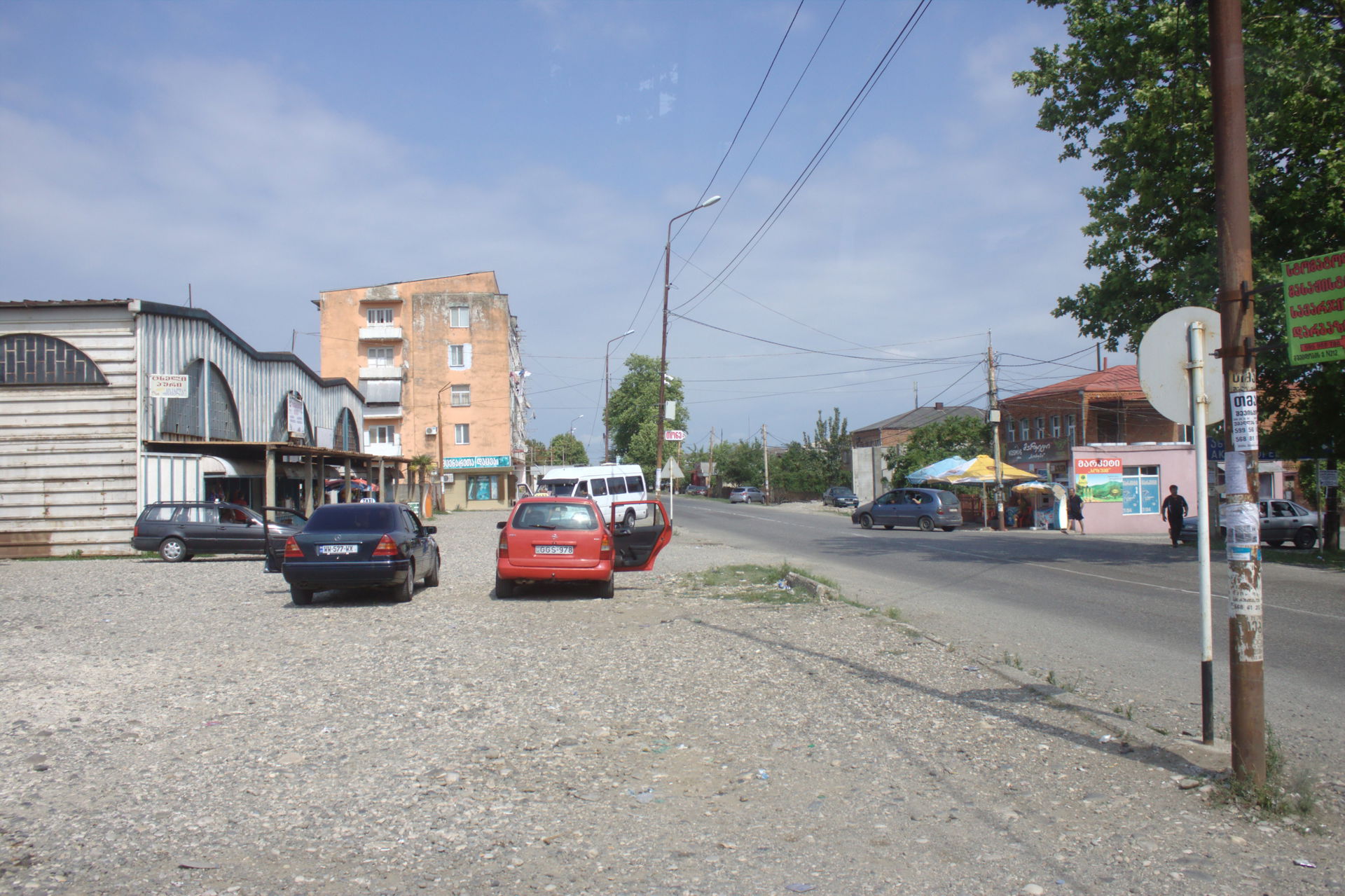 A parking lot in front of a covered marketplace in Senaki, Geor…